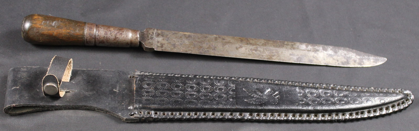 Large Civil War Era Fixed-Blade Knife (SNR): What appears to be a large file that was converted to a knife with a leather sheath. Consigner states they believe this to be American Civil War era. There is an embossed figure near the ricasso that 