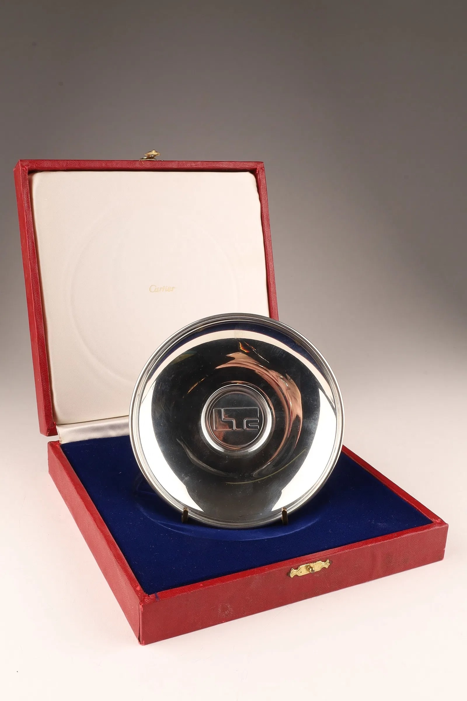 Cartier Vintage Polished Pewter Tray / Plate w/ Original Presentation Box, 4.75" diameter: Vintage Cartier polished pewter tray / plate with original presentation box. The tray measures 4.75" diameter, and the box measures 7" x 7". A sleek, reflective Cartier desk/vanity accessory with unde