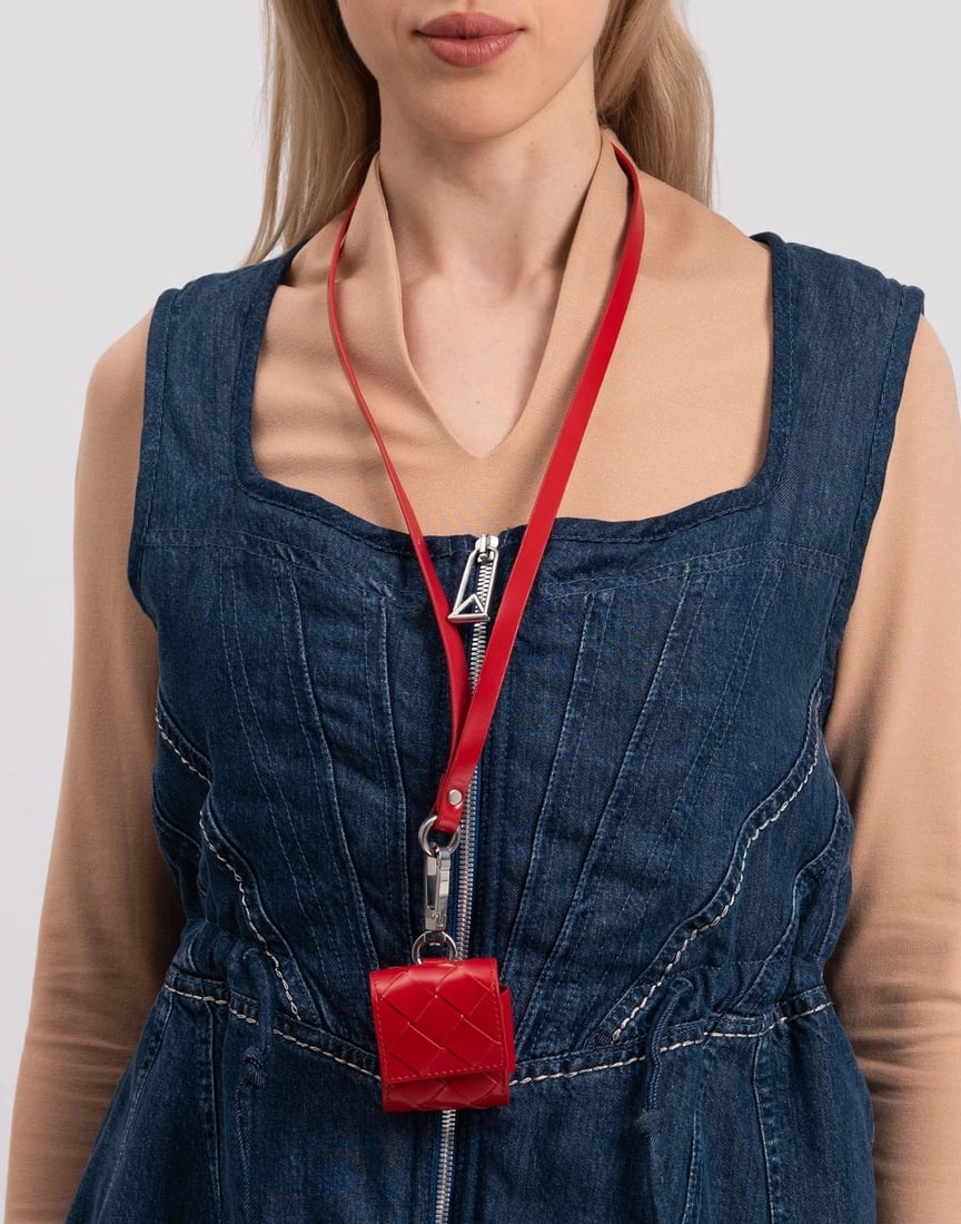 Bottega Veneta AirPods Lanyard Case Red: New Bottega Veneta leather lanyard headphone/AirPods case in red with Intrecciato paneling and popper flap closure. A practical and fashion-forward carry solution, ideal for travel and hands-free wear