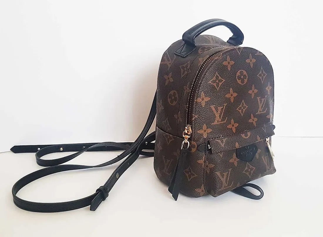 Louis Vuitton Palm Springs Mini Backpack in Monogram Coated Canvas w/ Black Calfskin Trim: Louis Vuitton Palm Springs Mini backpack in Monogram coated canvas with black calfskin trim. Features a front zip pocket and main zip compartment. Mini size with multi-position strap for versatile wea