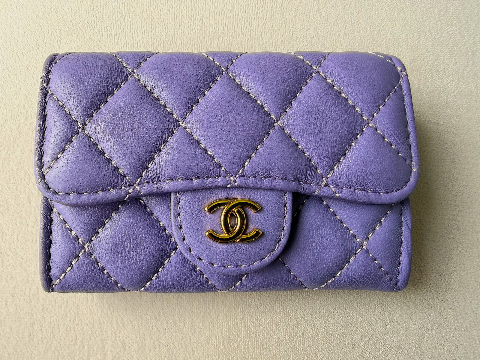 CHANEL Quilted Leather Flap Petite Wallet Lavender CC Snap w/ Dust Bag & box 4.5" x 3" x 1": Offered is a petite CHANEL quilted leather flap wallet/purse in a lavender/pastel purple tone with contrast stitching and gold-tone interlocking CC snap. The interior is lined in a deep burgundy texti