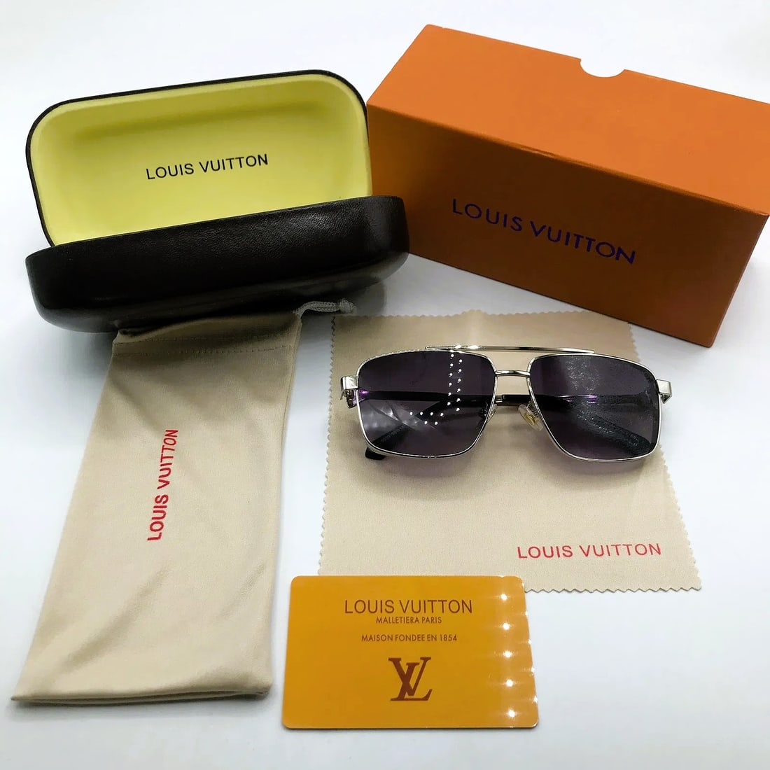 Louis Vuitton Silver Metal Sunglasses w/ Case, Cloth & Box: Metal-frame sunglasses marked Louis Vuitton, offered with branded case, pouch, cloth, and presentation materials as shown. This pair features silver-tone metal construction with purple-tinted lenses a
