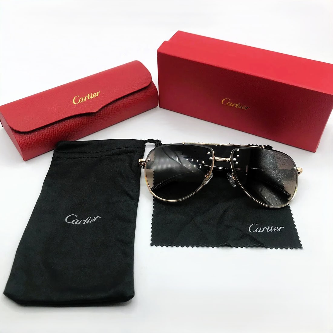Cartier Rimless Aviator Sunglasses w/ Gradient Lenses & Gold Hardware: Rimless aviator-style sunglasses marked Cartier, presented as shown. This pair features brown gradient lenses secured within gold-tone metal construction and minimalist bridge detailing. Cartier scrip