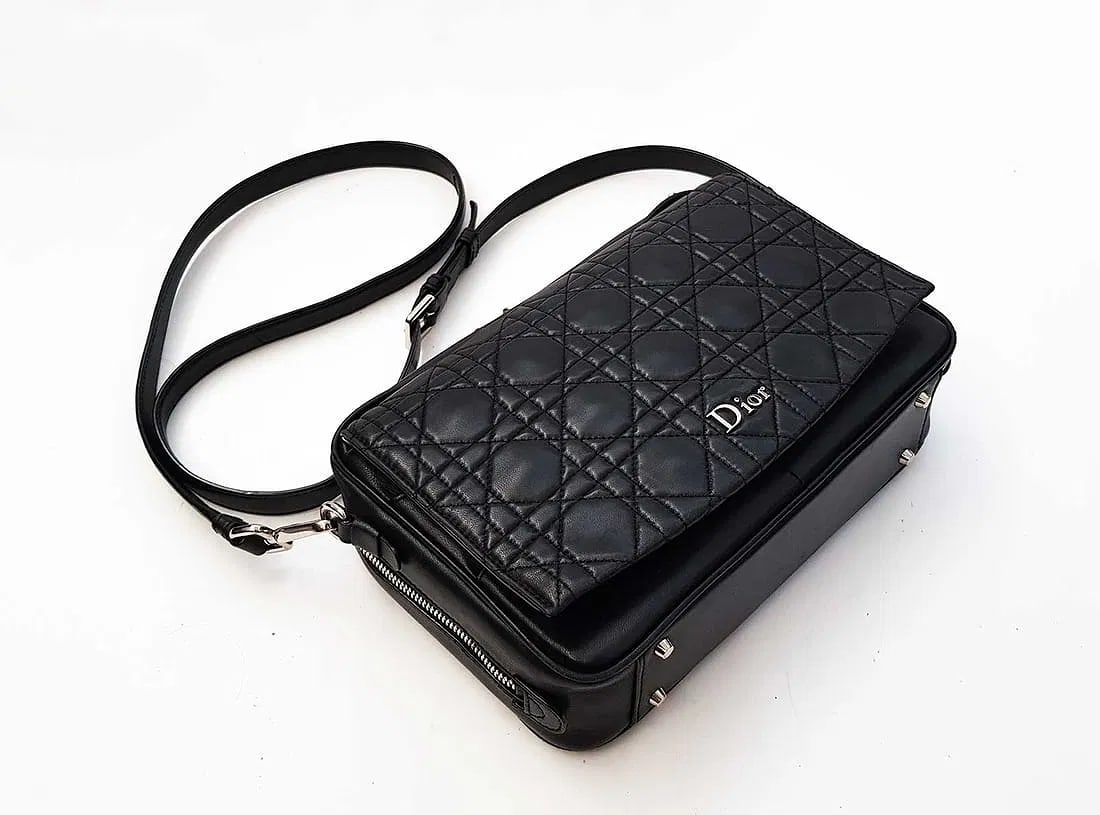 MSRP $5,950 Dior Shoulder Bag in Black Quilted Calfskin Leather w/ Macrocannage Pattern: Pre-loved Dior shoulder bag in black quilted calfskin leather with Macrocannage pattern. Top zipper closure and adjustable leather strap. Interior includes a zip pocket and patch pocket. Front flap wi