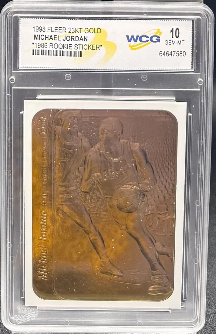 1998 Fleer 23KT Gold Michael Jordan "1986 Rookie Sticker" – WCG GEM–MT 10 – Rare: An exceptional sports collectible: a pristine WCG GEM MINT 10 example of Michael Jordan’s 1998 Fleer 23KT Gold "1986 Rookie Sticker" commemorative. The composition features a gold–plated r