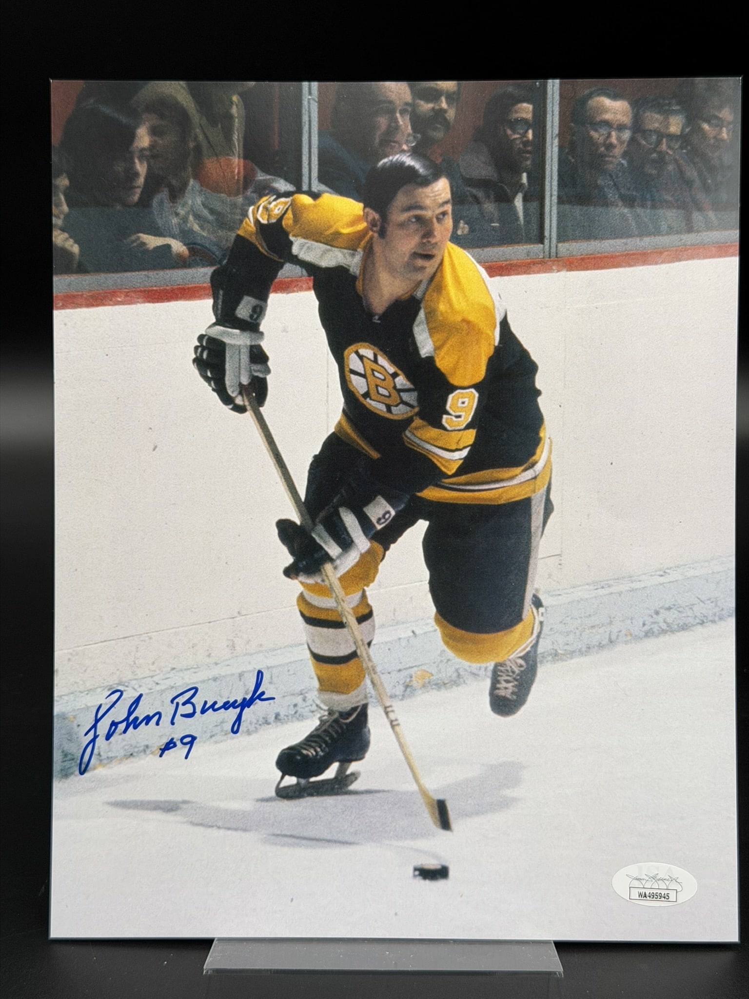 John Bucyk Signed Boston Bruins 8" x 10" Color Photo JSA COA: Color photograph personally signed by Boston Bruins legend John Bucyk in bold blue marker, adding his iconic jersey number "9" beneath the signature. The image depicts Bucyk in action wearing the clas