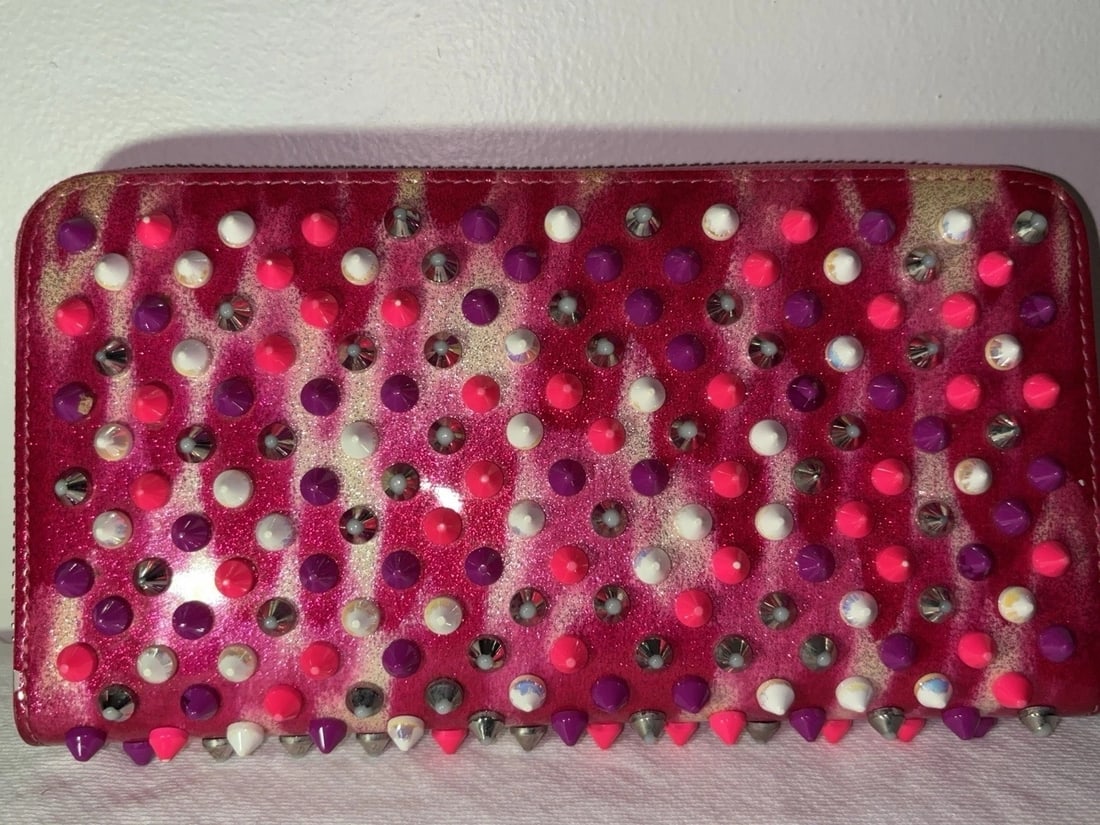 MSRP $1,495 CHRISTIAN LOUBOUTIN Panettone Spiked Wallet Pink: Christian Louboutin Panettone Zip-Around Wallet in Marble Pink spiked leather with multicolor studs/spikes and zip-around closure. Bold, collectible Louboutin style with ample interior organization fo