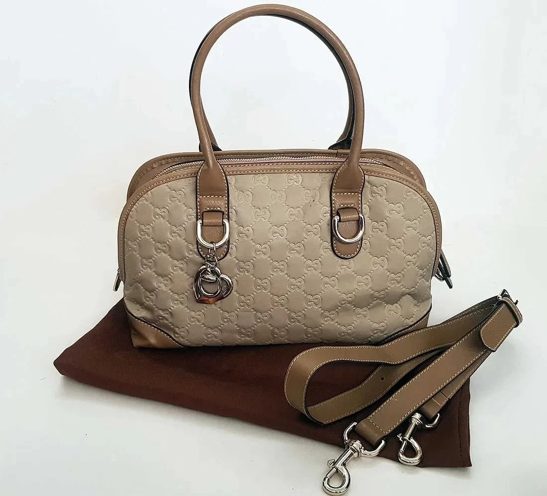 MSRP $3,250 GUCCI Guccissima Beige Metallic Satchel w/ Strap COA: GUCCI Metallic Beige Guccissima Boston Satchel Crossbody 269955 9643 Heart Charm w/ Strap & Dust Bag & Certificate of Authenticity (COA) Elegant and timeless GUCCI Guccissima top-handle satche