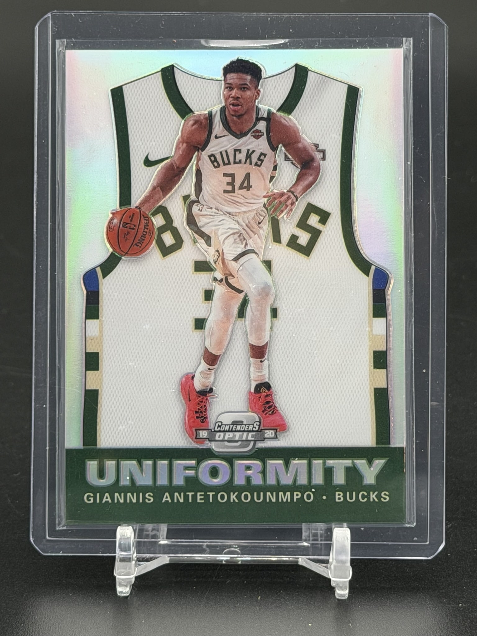 2019-20 Panini Contenders Optic Giannis Antetokounmpo Uniformity Prizm Insert #32 Milwaukee Bucks: 2019-20 Panini Contenders Optic Giannis Antetokounmpo Uniformity Prizm insert card #32, featuring the Milwaukee Bucks superstar. The front of this card showcases an action photograph of Antetokounmpo 