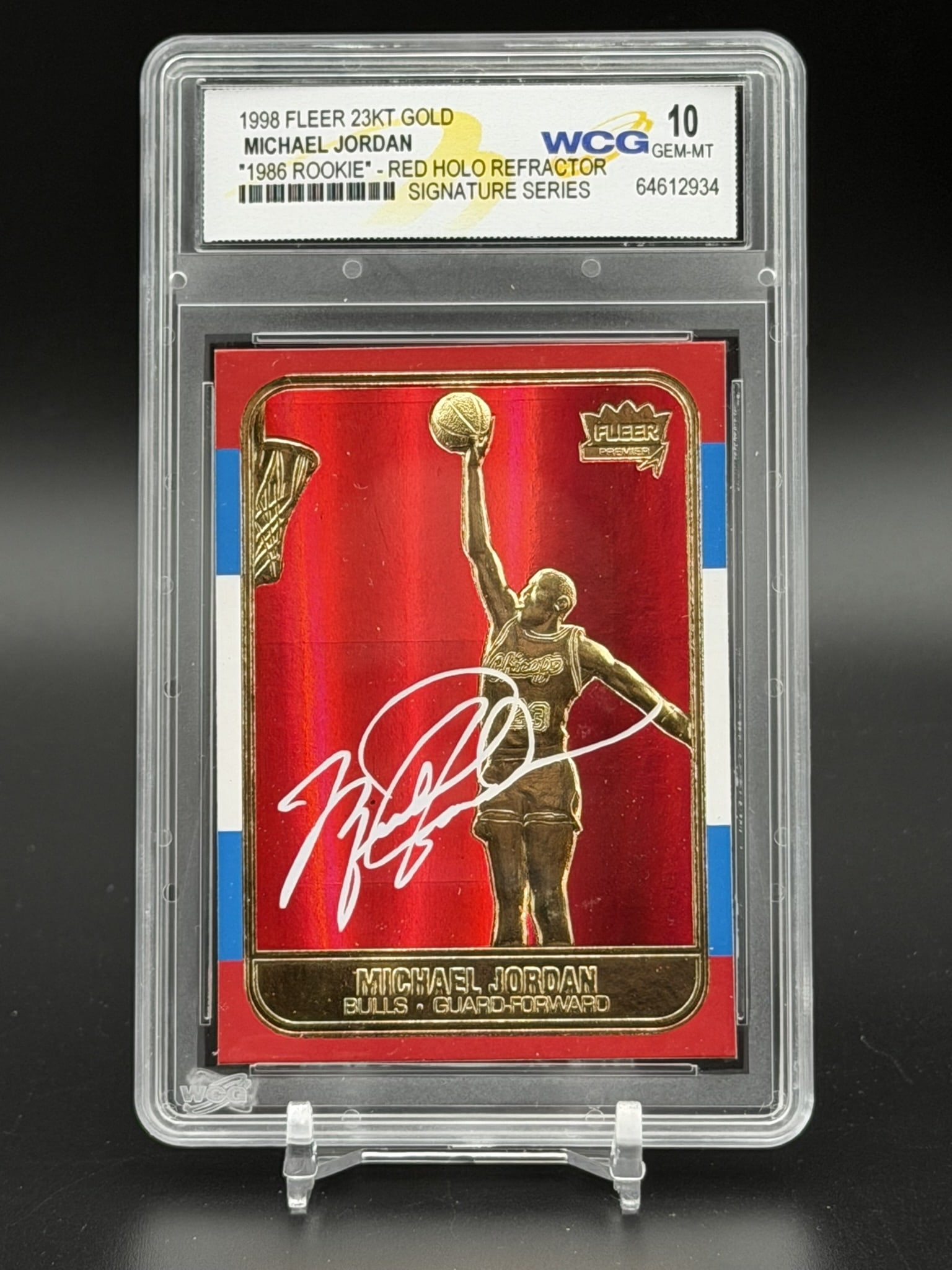1998 Fleer 23KT Gold Michael Jordan 1986 Rookie Red Holo Refractor WCG GEM MT 10 Signature Series: 1998 Fleer 23KT Gold Michael Jordan Signature Series card, professionally graded WCG Gem-MT 10. This premium metallic parallel pays tribute to his iconic 1986 rookie card design, showcasing a sculpted