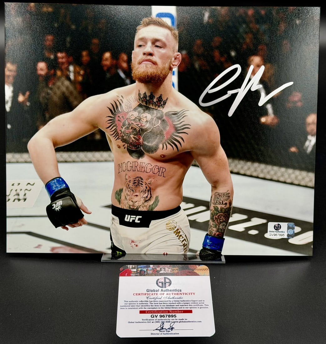 Conor McGregor Signed UFC MMA Photo GA COA 8" × 10": Conor McGregor Signed 8" × 10" UFC Photo w/ Global Authentics COA Official 8" × 10" photograph personally signed by Conor McGregor in bold silver marker. The photograph