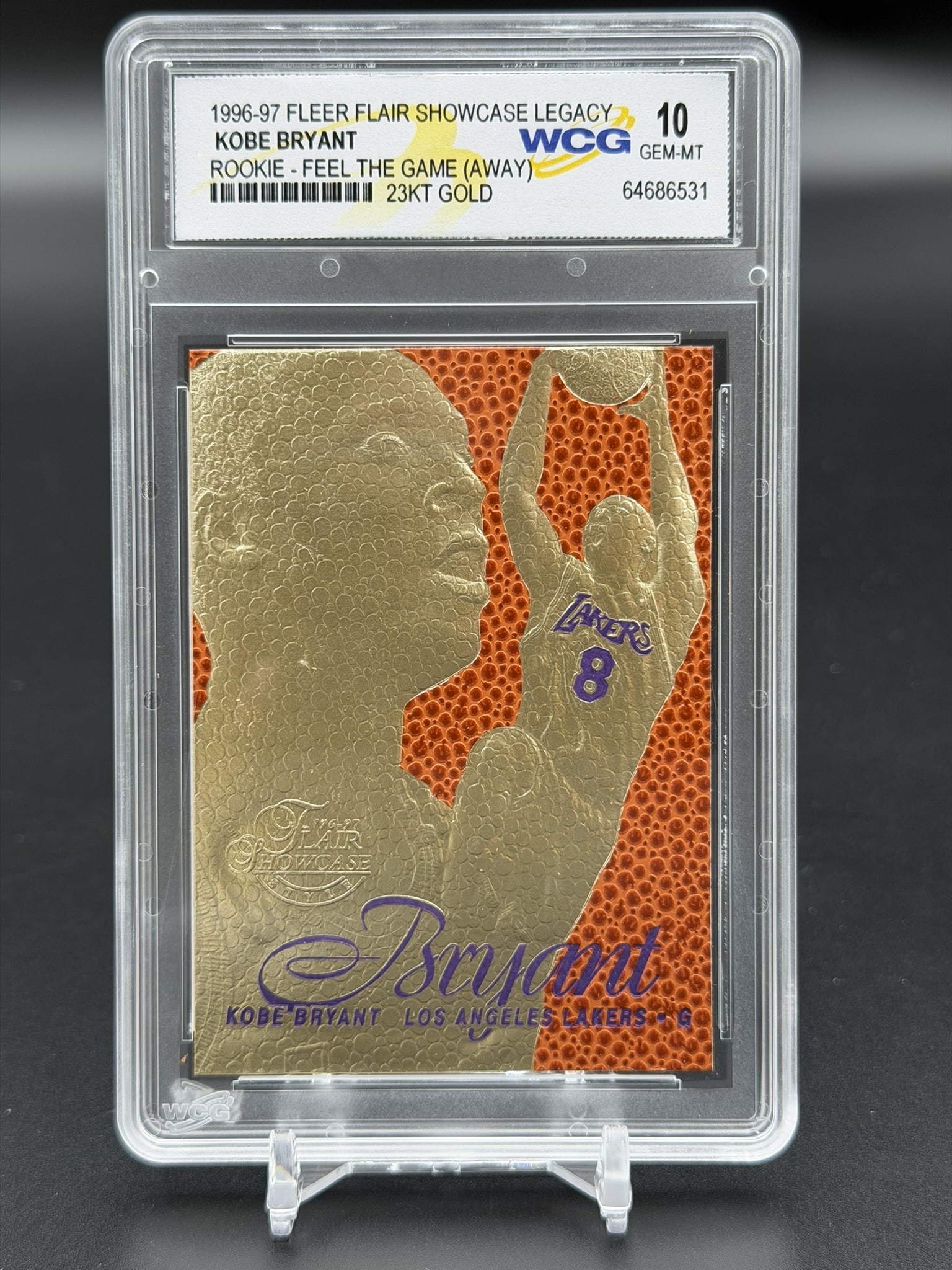 1996-97 Fleer Flair Showcase Legacy Kobe Bryant 23KT Gold Card WCG 10 Gem-MT Rookie Feel The Game: An exceptional sports collectible: a pristine WCG GEM MINT 10 example of Kobe Bryant’s 1996–97 Fleer Flair Showcase Legacy "Feel The Game" 23KT gold rookie commemorative. The composition f