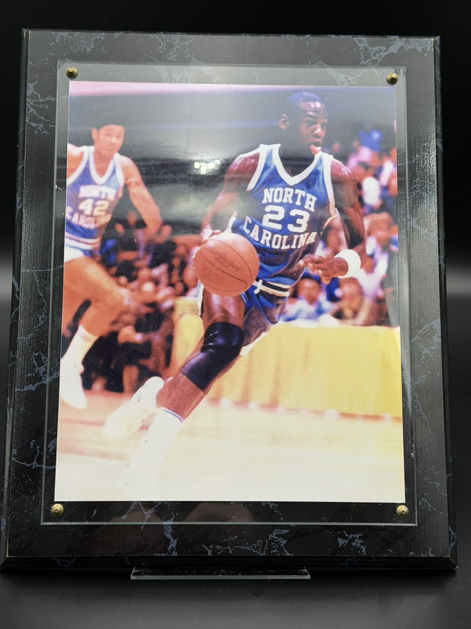 Vintage Michael Jordan North Carolina UNC Framed NCAA Basketball Print Wall Display 10" x 12": Vintage framed display featuring an action image of Michael Jordan during his collegiate career with the University of North Carolina Tar Heels. The color print depicts Jordan wearing his iconic No. 2