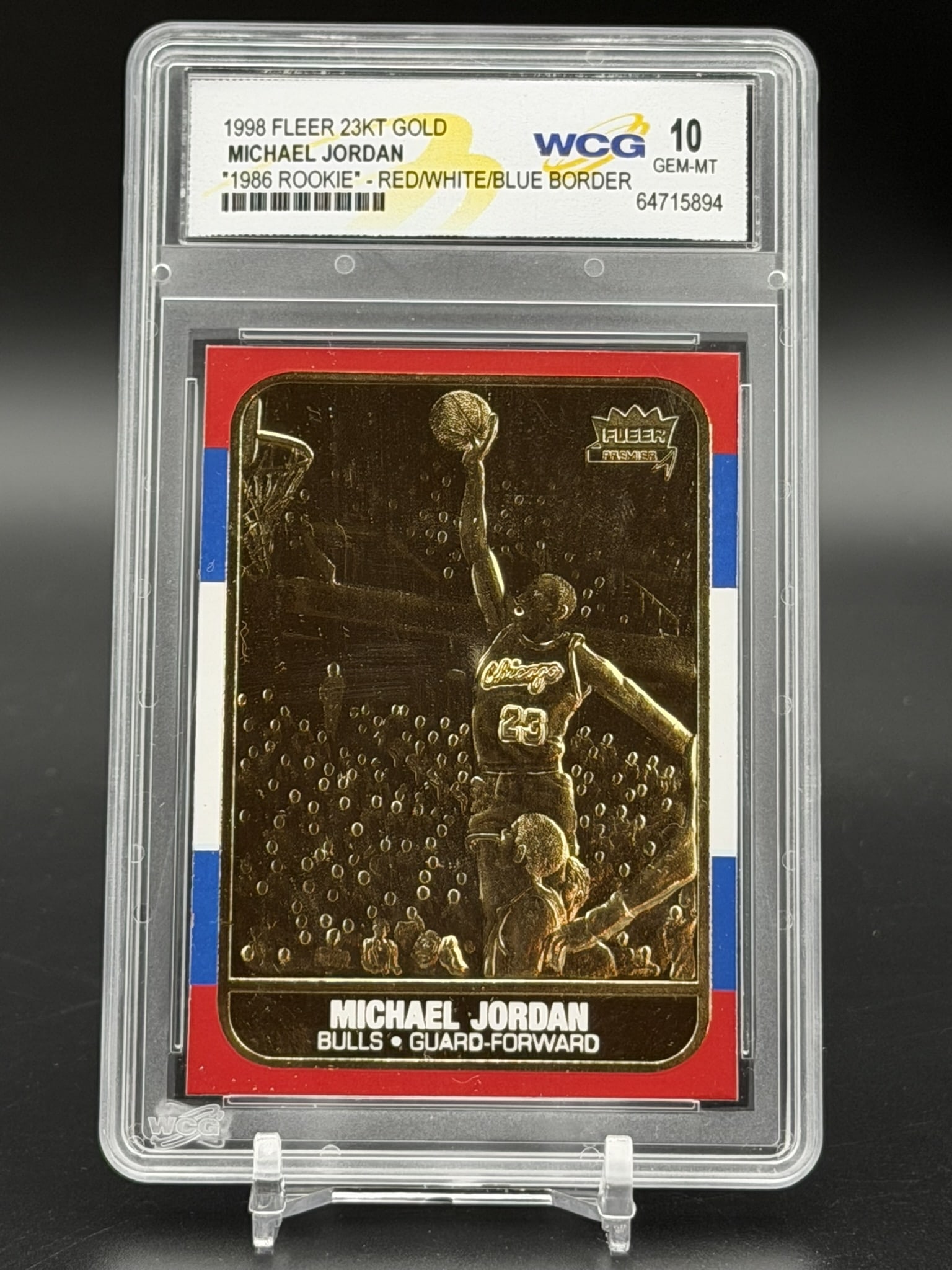 1998 Fleer 23KT Gold Michael Jordan 1986 Rookie Red/White/Blue Border WCG GEM MT 10 Rare Retro: An exceptional sports collectible: a pristine WCG GEM MINT 10 example of Michael Jordan’s 1998 Fleer 23KT Gold "1986 Rookie" Red/White/Blue Border. The composition features a patriotic tri&ndash
