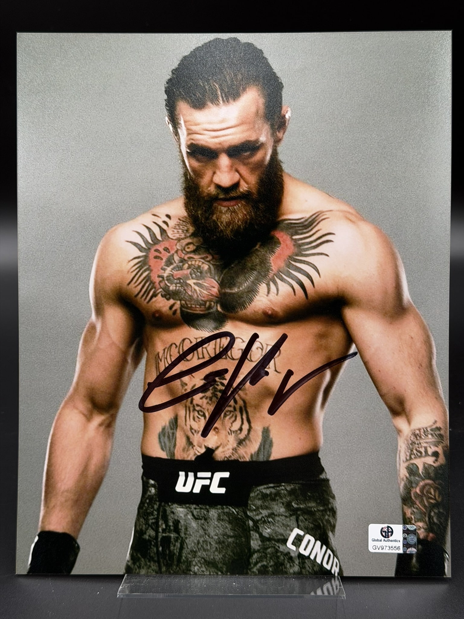 Conor McGregor Signed UFC MMA Portrait Photo GA COA 8" × 10": Color photograph personally signed by Conor McGregor in bold black marker across the center of the image. The striking portrait captures "The Notorious" in a focused pre-fight pose, prominently displa