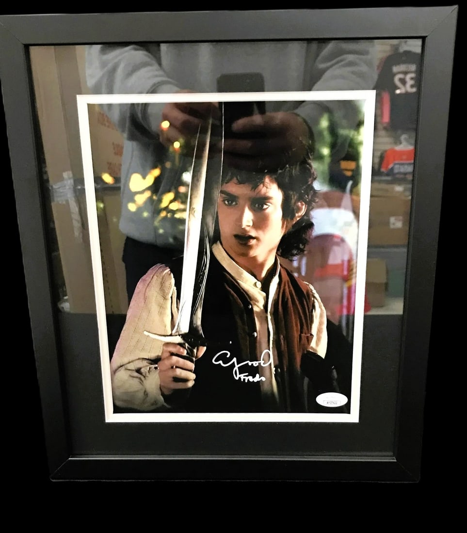Elijah Wood Signed Framed The Lord of the Rings Photo 8"x10" JSA COA: Elijah Wood signed The Lord of the Rings 8x10 photo, professionally framed. Signature appears on the photo (white ink). Accompanied by JSA authentication. Highlights Elijah Wood autograph on LOTR 8x10