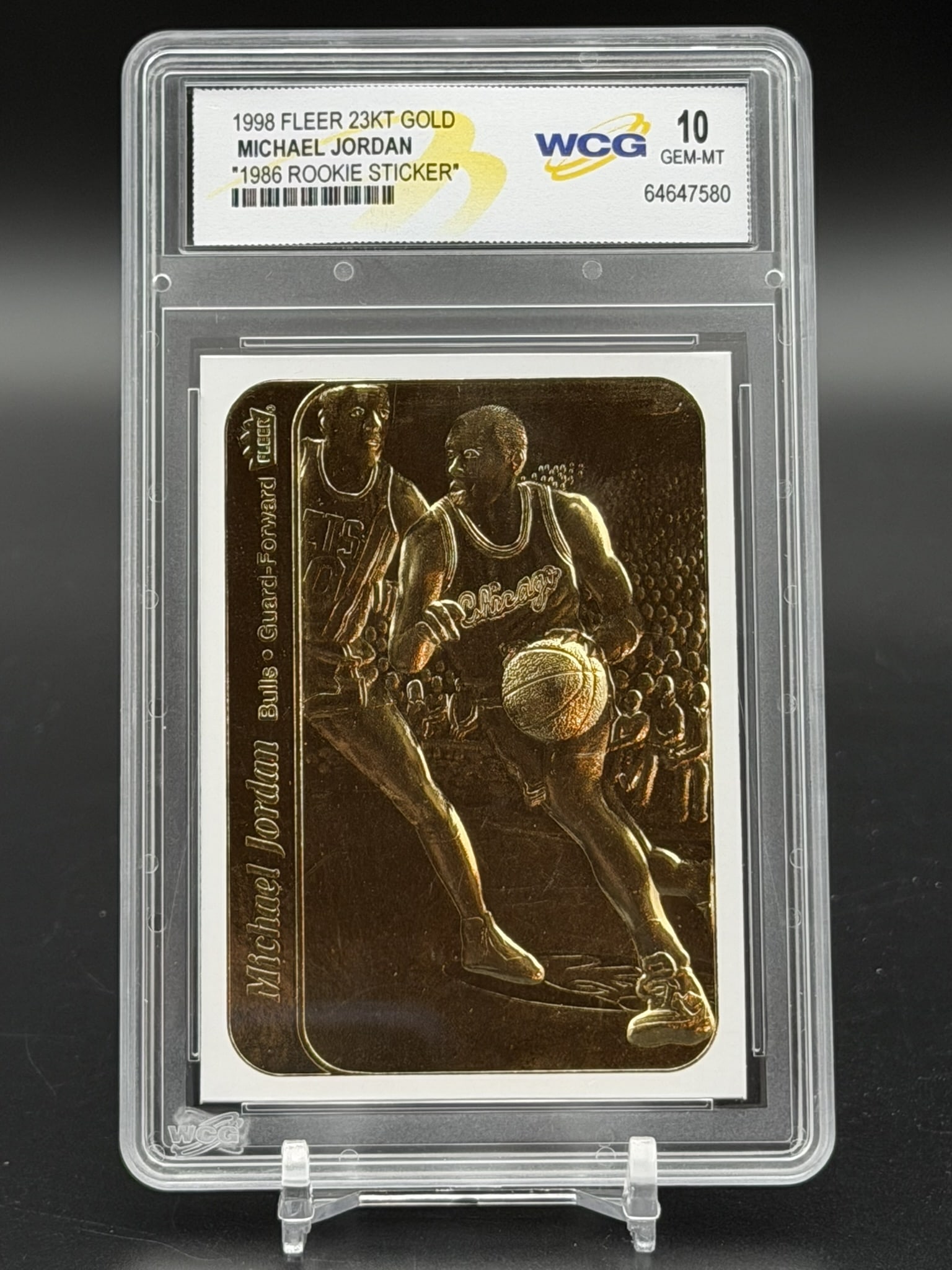 1998 Fleer 23KT Gold Michael Jordan "1986 Rookie Sticker" – WCG GEM–MT 10 – Rare: An exceptional sports collectible: a pristine WCG GEM MINT 10 example of Michael Jordan’s 1998 Fleer 23KT Gold "1986 Rookie Sticker" commemorative. The composition features a gold–plated r