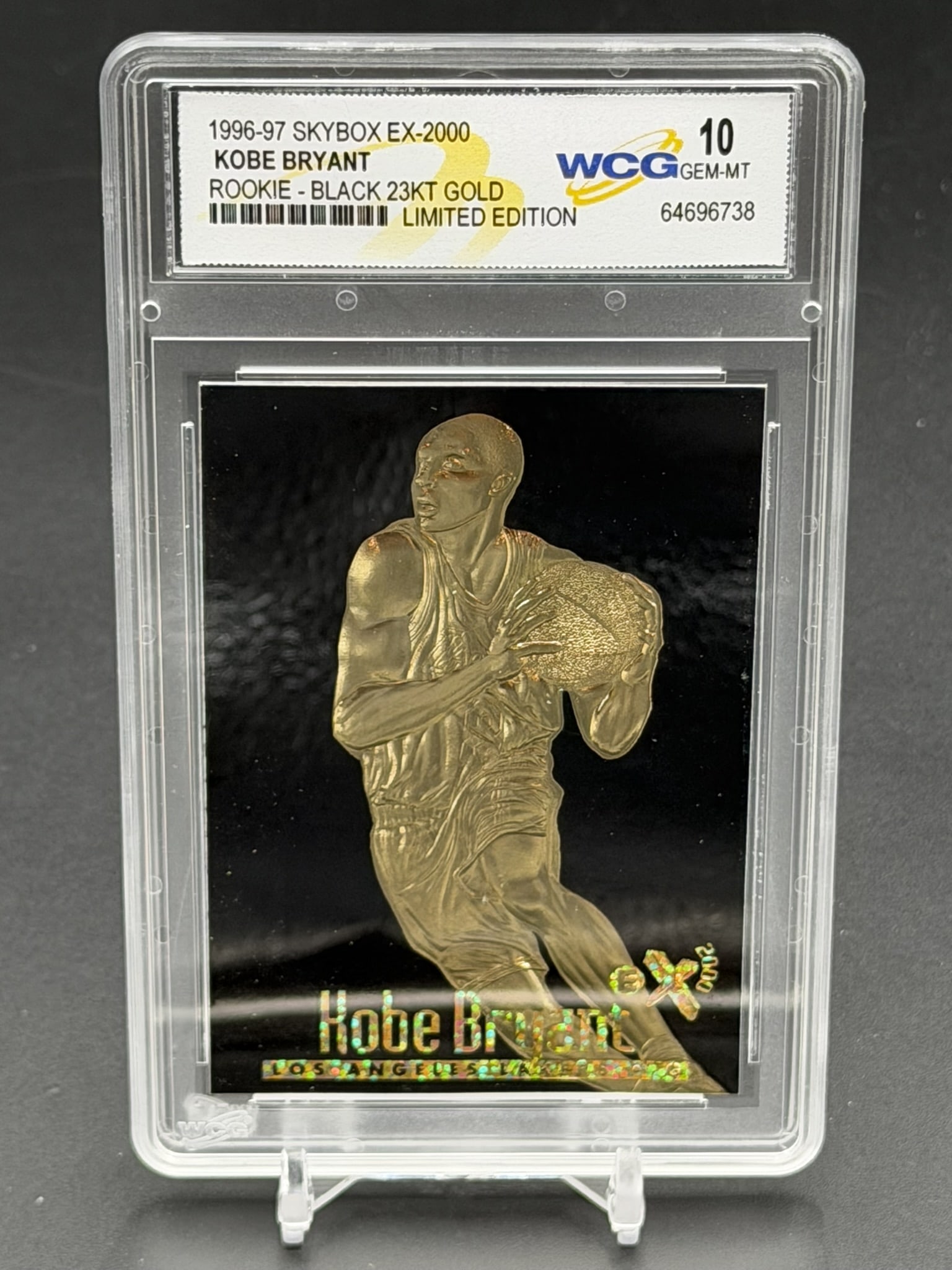 1996-97 SkyBox EX-2000 Black 23KT Gold Kobe Bryant WCG GEM-MT 10 Rookie Card Limited Edition #12540: 1996-97 SkyBox E-X2000 23KT Gold Kobe Bryant rookie-era card featuring a black background and holographic lettering, professionally graded WCG Gem-MT 10. Designated as the "Rookie - Black 23KT Gold Li