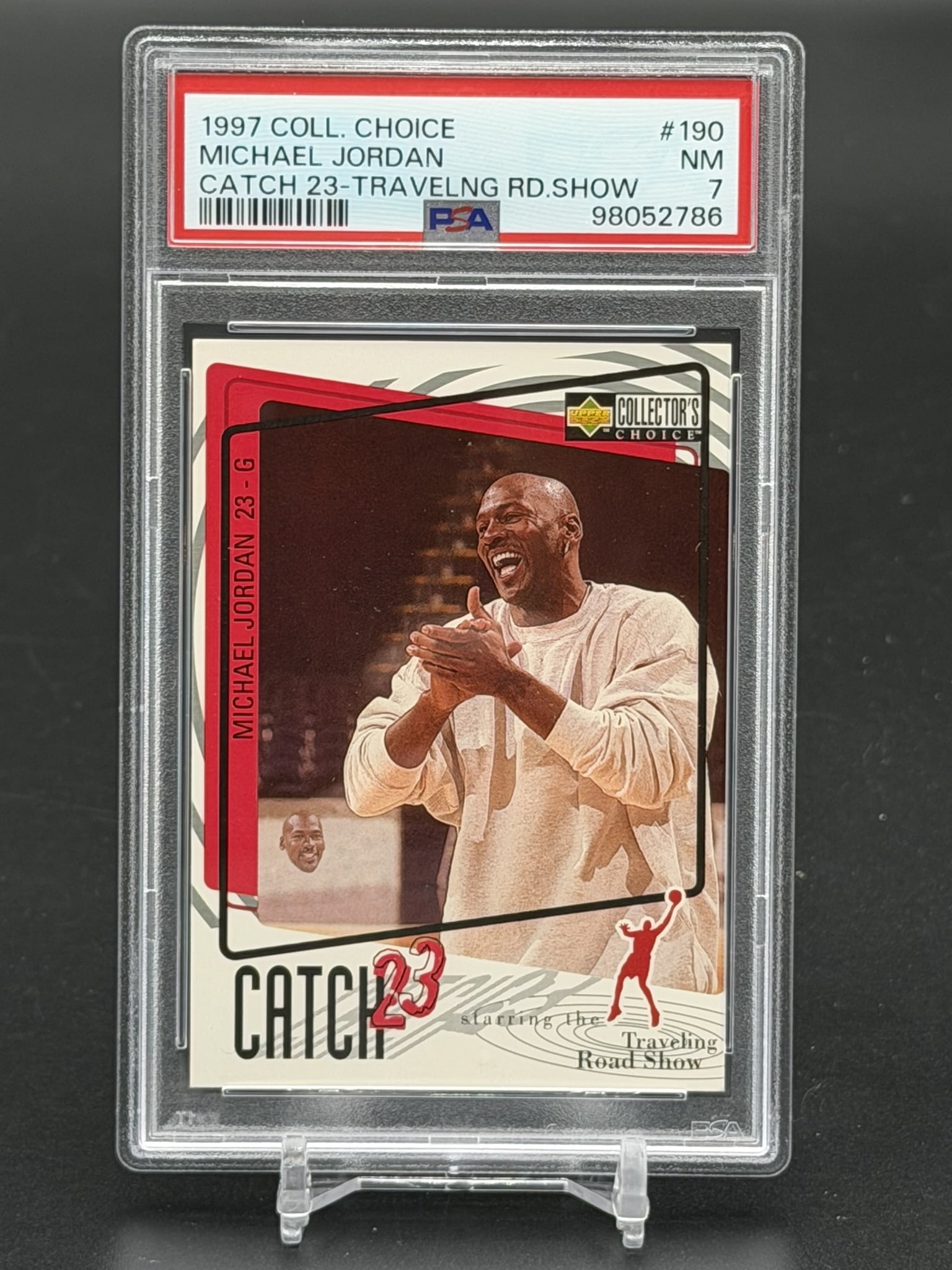 1997 Upper Deck Collector's Choice Michael Jordan Catch 23 #190 PSA 7 NM Chicago Bulls Card: 1997 Upper Deck Collector's Choice Michael Jordan Catch 23 insert card #190, professionally graded PSA Near Mint 7. Subtitled "Catch 23 - Travelng Rd.Show," the front of this card features a primary p