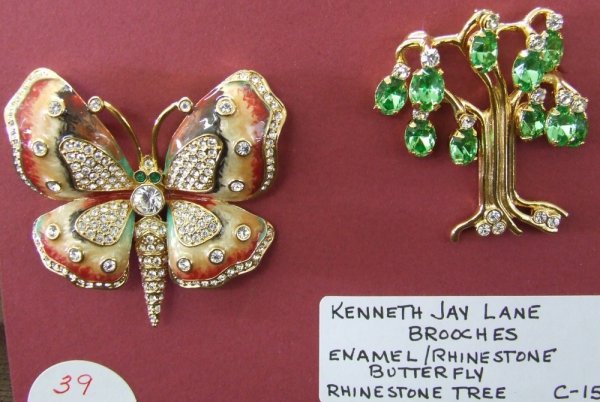 Kenneth Jay Lane Brooches: 2 Brooch grouping features an enamel and rhinestone butterfly in creams and rust along with a gold-tone tree w/green dangle rhinestone leaves.