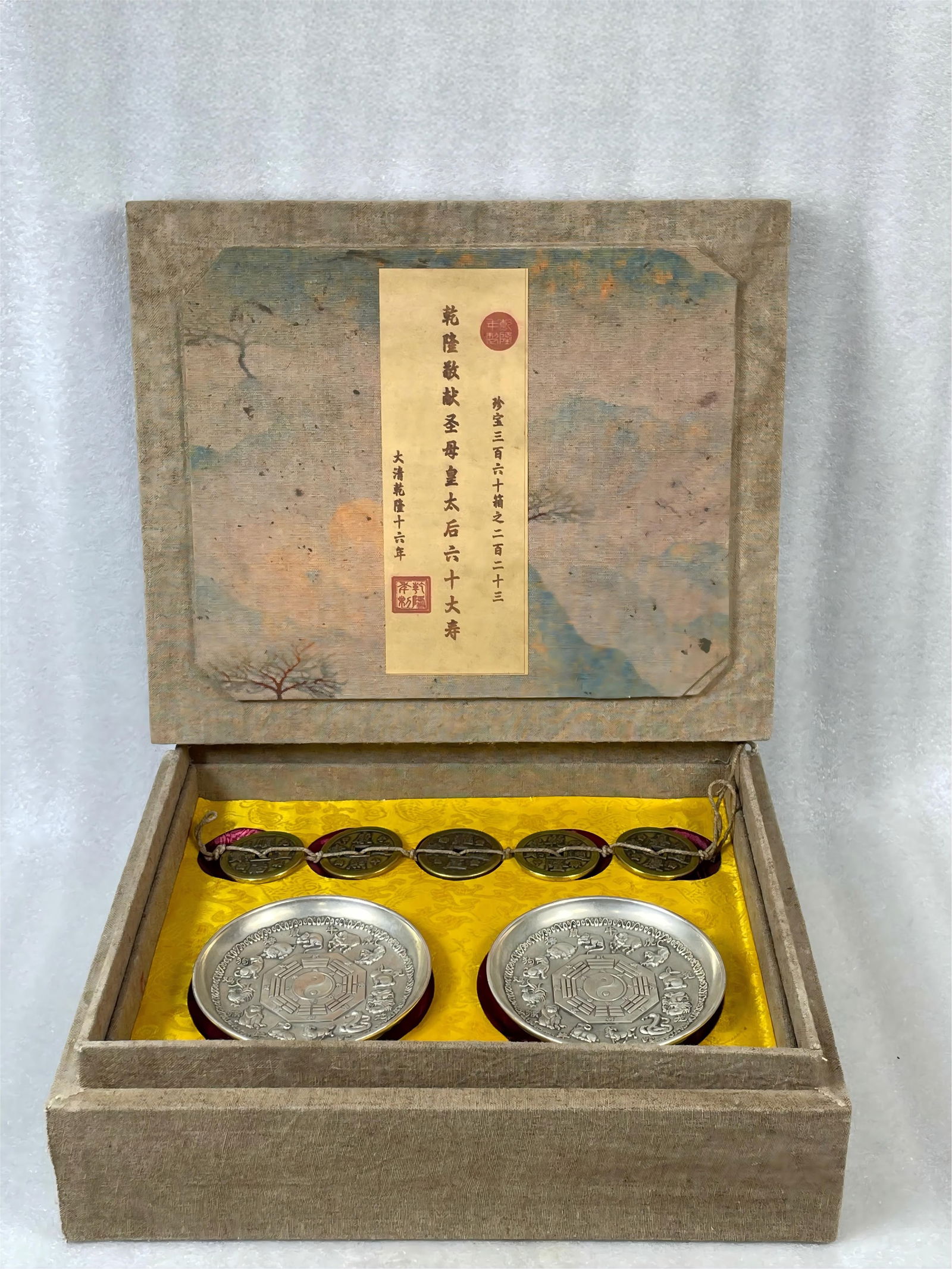 A set of collectible gilded silver twelve zodiac animal Bagua appreciation plate and five emperor: A collectible silver-plated plate depicting the twelve zodiac animals and eight trigrams, along with a set of five emperor coins, measuring 32x27x10cm and weighing 3000g. Provenance:From a noted priva