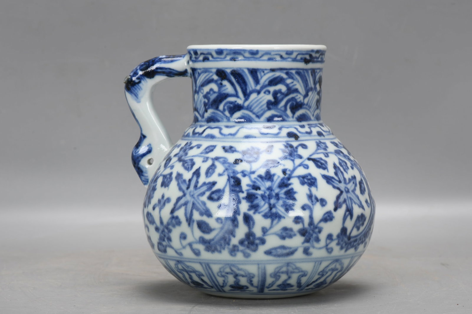 A Ming Dynasty Xuande period ewer with a design of waves and branches. (1 of 9)