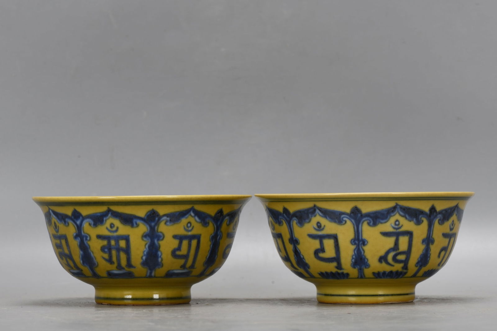 A pair of Ming Dynasty Xuande period yellow-ground blue-and-white porcelain bowls with inscriptions. (1 of 9)