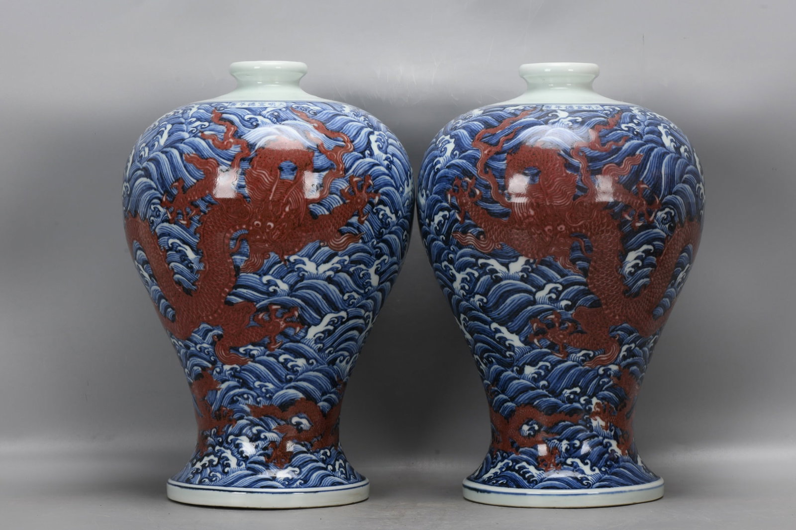 A pair of blue-and-white underglaze red plum vases with sea dragon design from the Xuande period of: pair of blue-and-white underglaze red plum vases with a sea dragon design from the Xuande period of the Ming Dynasty. They are 39.5 cm high, 7.5 cm in diameter at the mouth, 26.5 cm in diameter at the