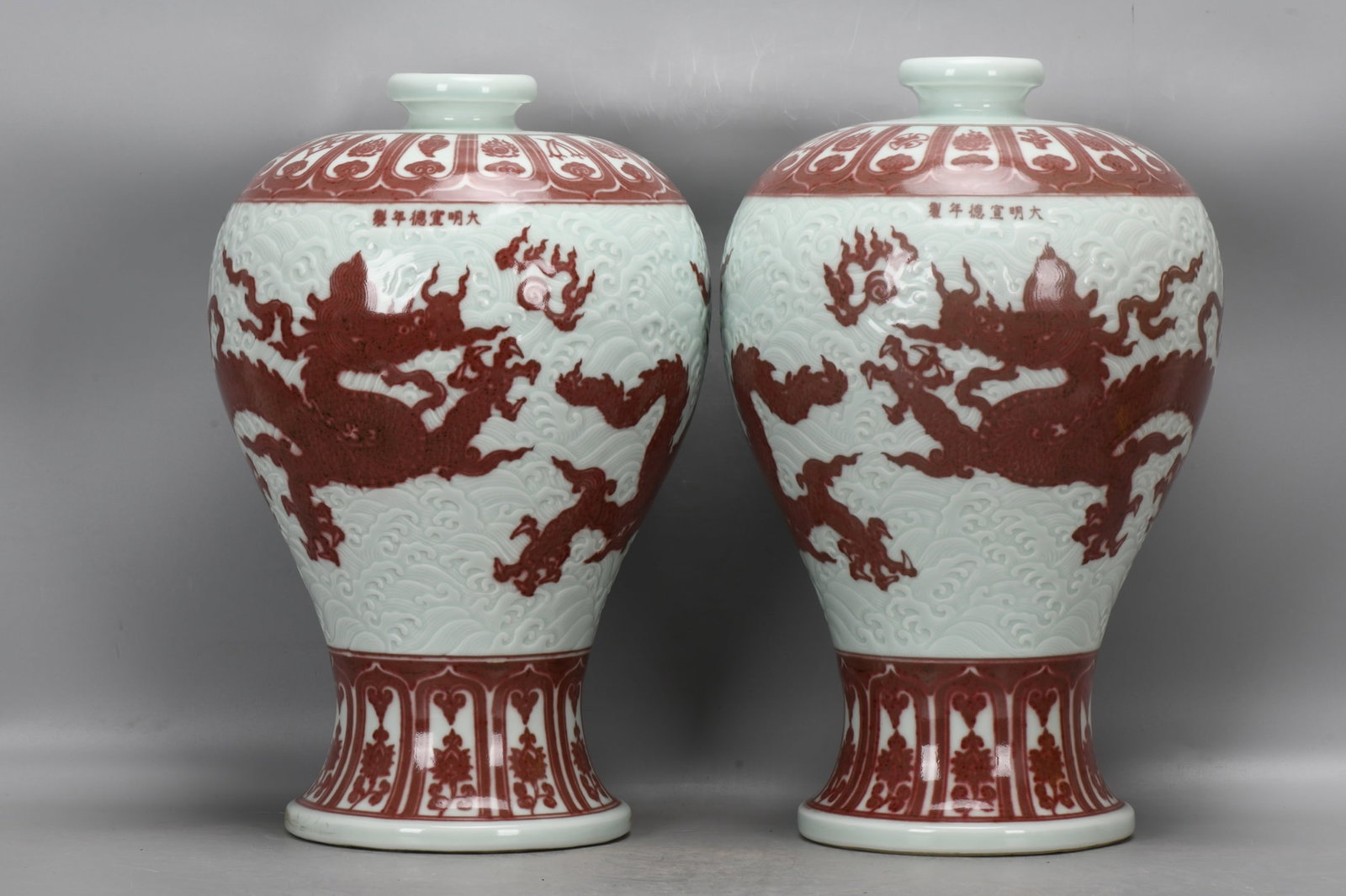 A pair of Ming Dynasty Xuande underglaze red plum vases with carved sea dragon and auspicious (1 of 9)