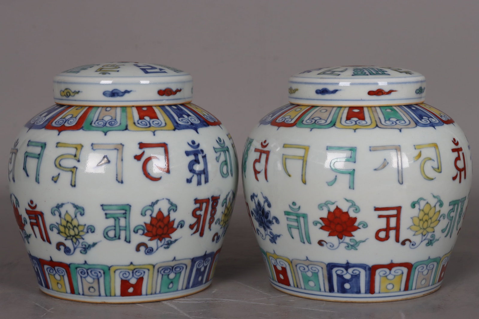 A pair of Ming and Chenghua period polychrome Sanskrit floral jars with the character "??" (tian) (1 of 9)