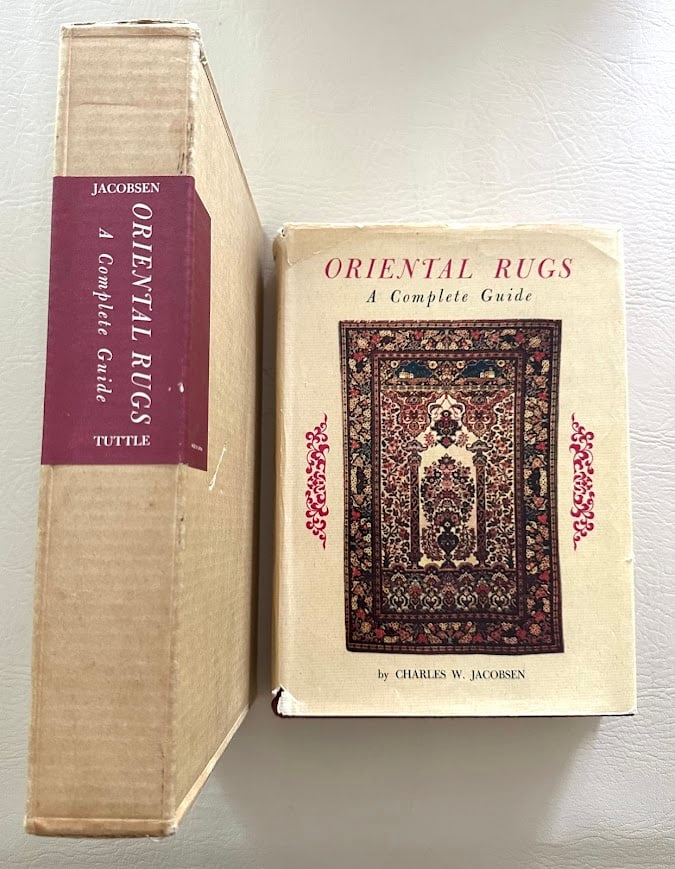 Oriental Rugs. A Complete Guide, by Charles Jacobsen.: Rutland: 1962. 4to; 479pp; gilt decorative cloth; color pictorial jacket; with approximately 200 illustrations; jacket quite worn; book is in fine condition, in the original publisher's slipcase.