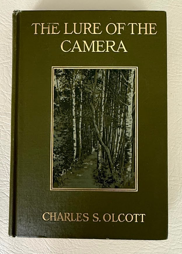 The Lure of the Camera, by Charles Olcott.: Boston: Houghton Mifflin, 1914. 8vo; 301pp; gilt lettered cloth with a photographic plate on the front cover; illustrated with a frontispiece and 47 photographic plates; covers with a few small light 