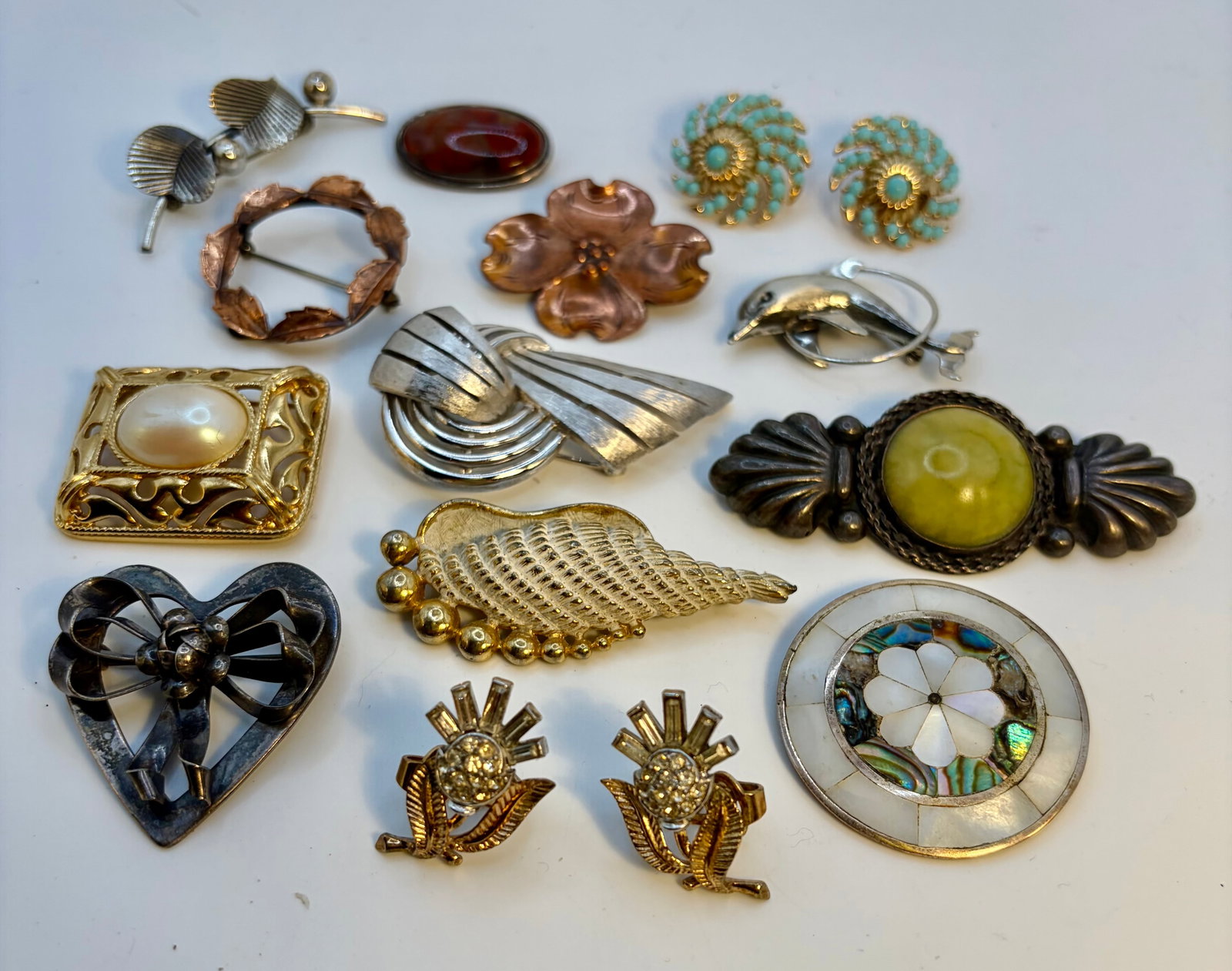 Collection of Name Brand and/or Precious Metal Jewelry: A collection of vintage name brand and or precious metal jewelry. Included are two pairs of clip-on Trifari earrings, two sterling silver pins by Beau, a silver-toned Trifari brooch, 2 copper pins by 