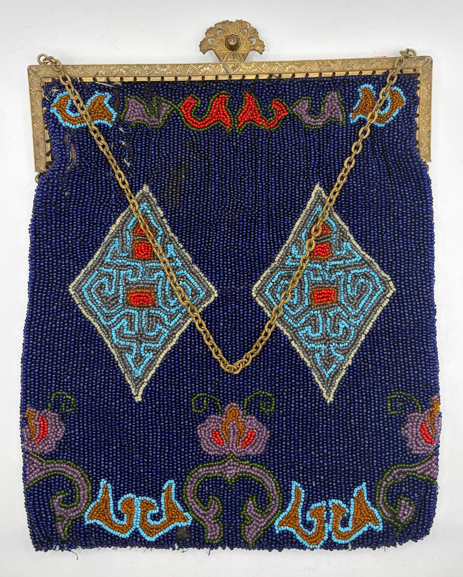 Antique Beaded Handbag: An antique Art Deco beaded handbag, likely from the 1920-1930s featuring a stunning background in hand-sewn cobalt blue seed beads. The bag’s designs are sewn from turquoise, red, grey, cream, o