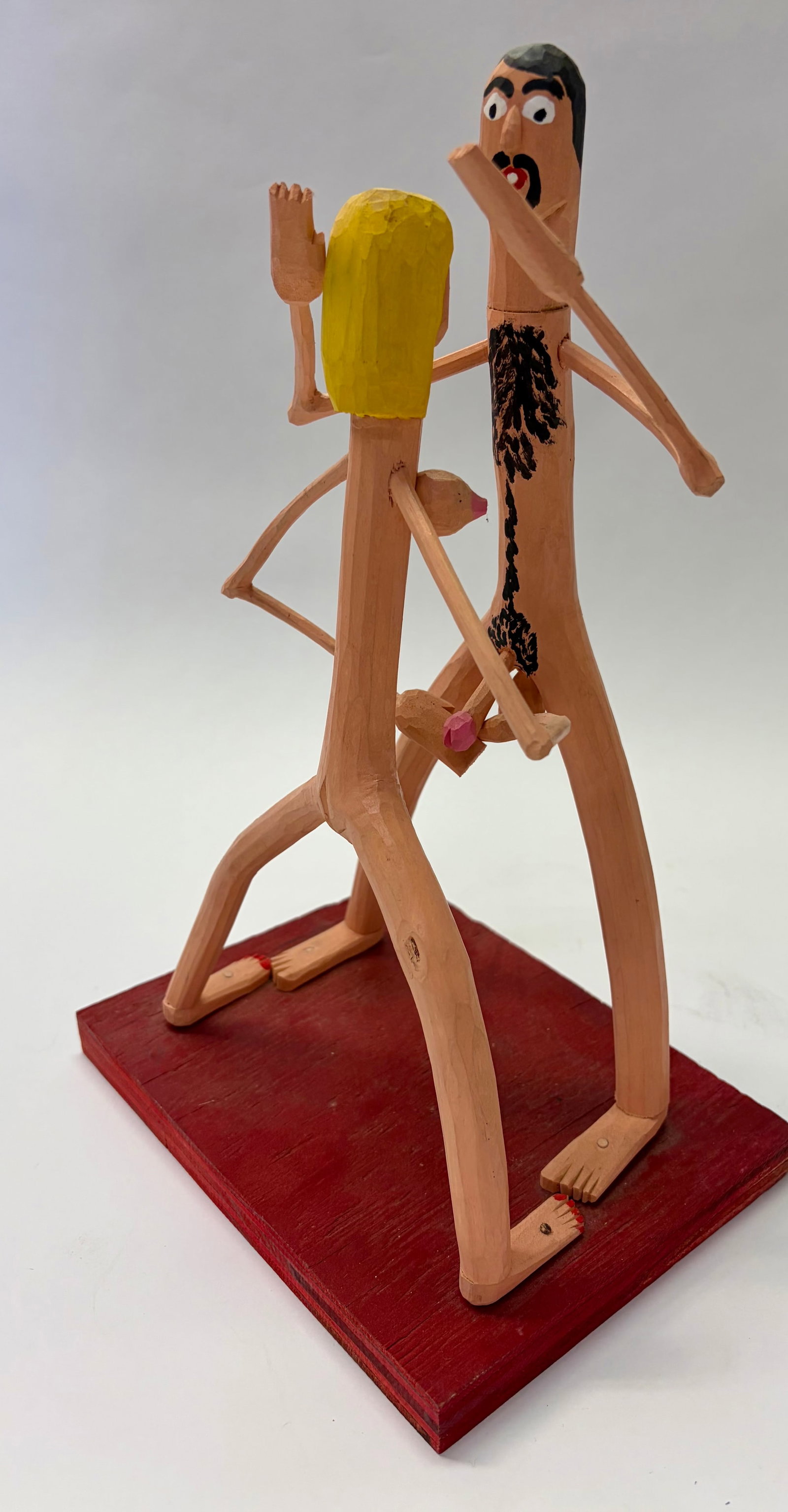Harry Jennings Signed Folk Art Sculpture: A folk art sculpture of a naked couple signed Harry Jennings, born in 1966. He is a popular Kentucky based, self-taught woodcarver. The base measures 6” x 8” and the sculpture stands 13