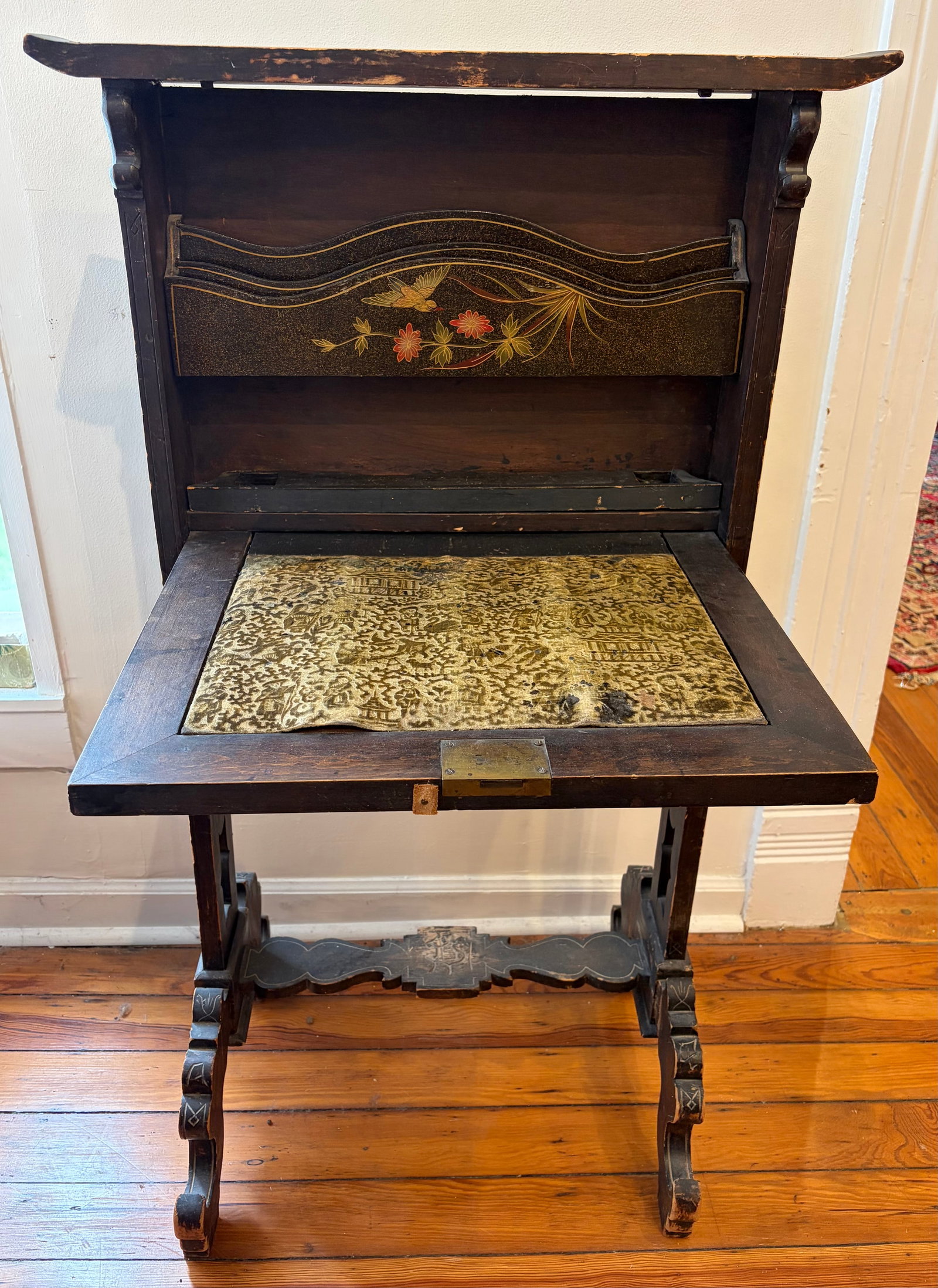 Antique Chinoiserie Hand-Painted Drop-Down Desk: An antique walnut secretary desk having a drop down writing surface covered with a fabric inlay. The piece features carved supports, decorative hardware, shallow carvings and hand- painted motifs. It 