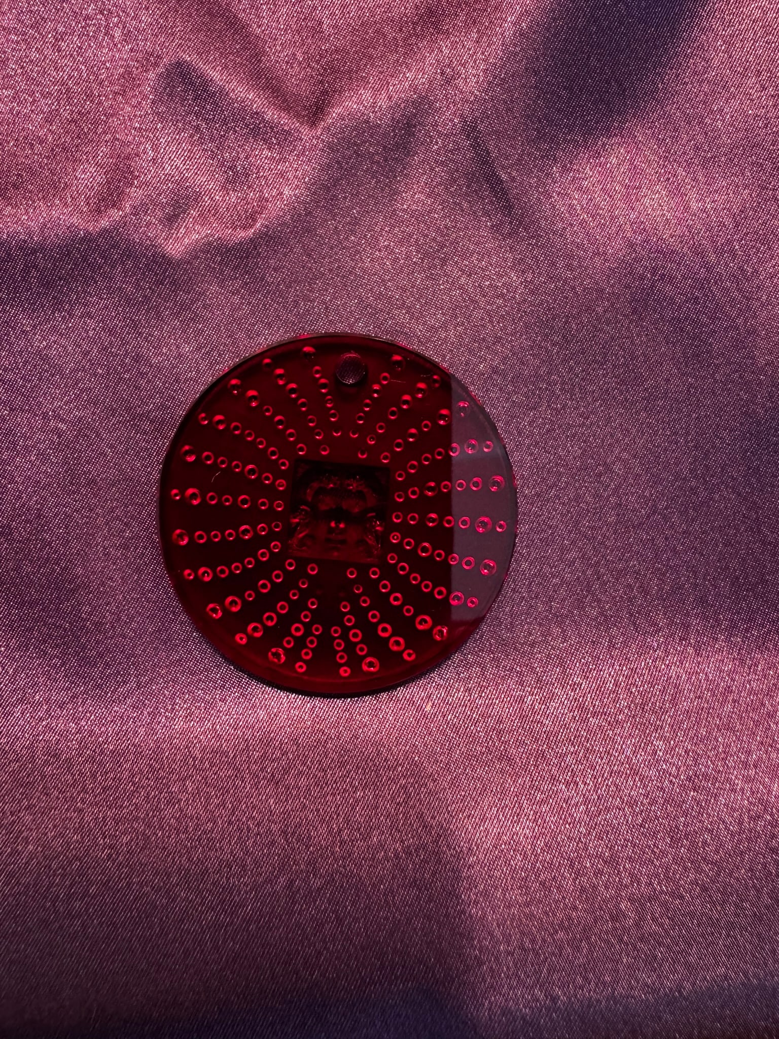 Lalique Ruby Red Sunburst Face Ornament 2011: Rare Lalique France ruby red crystal holiday ornament featuring a central classical face/masque motif surrounded by a radiating sunburst design.