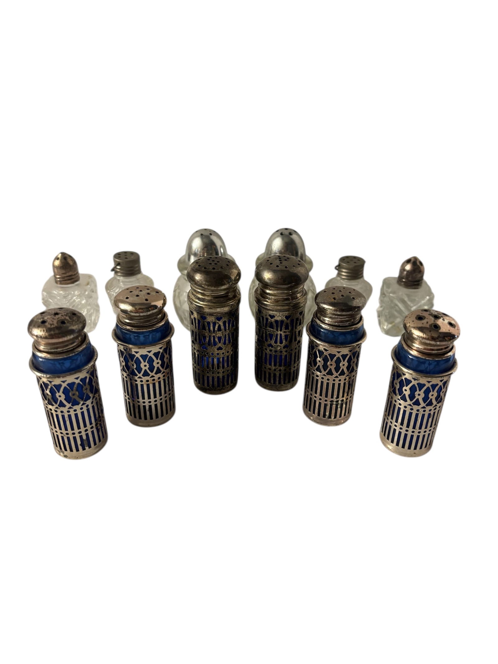 Collection of Cobalt Blue and Silver Plated Salt & Pepper Shakers: Featuring 3 various sets with distinctive pierced filigree silver plated casings over vibrant cobalt blue glass liners. Hong Kong marked on Heart design shakers. Also included in lot various mid centu