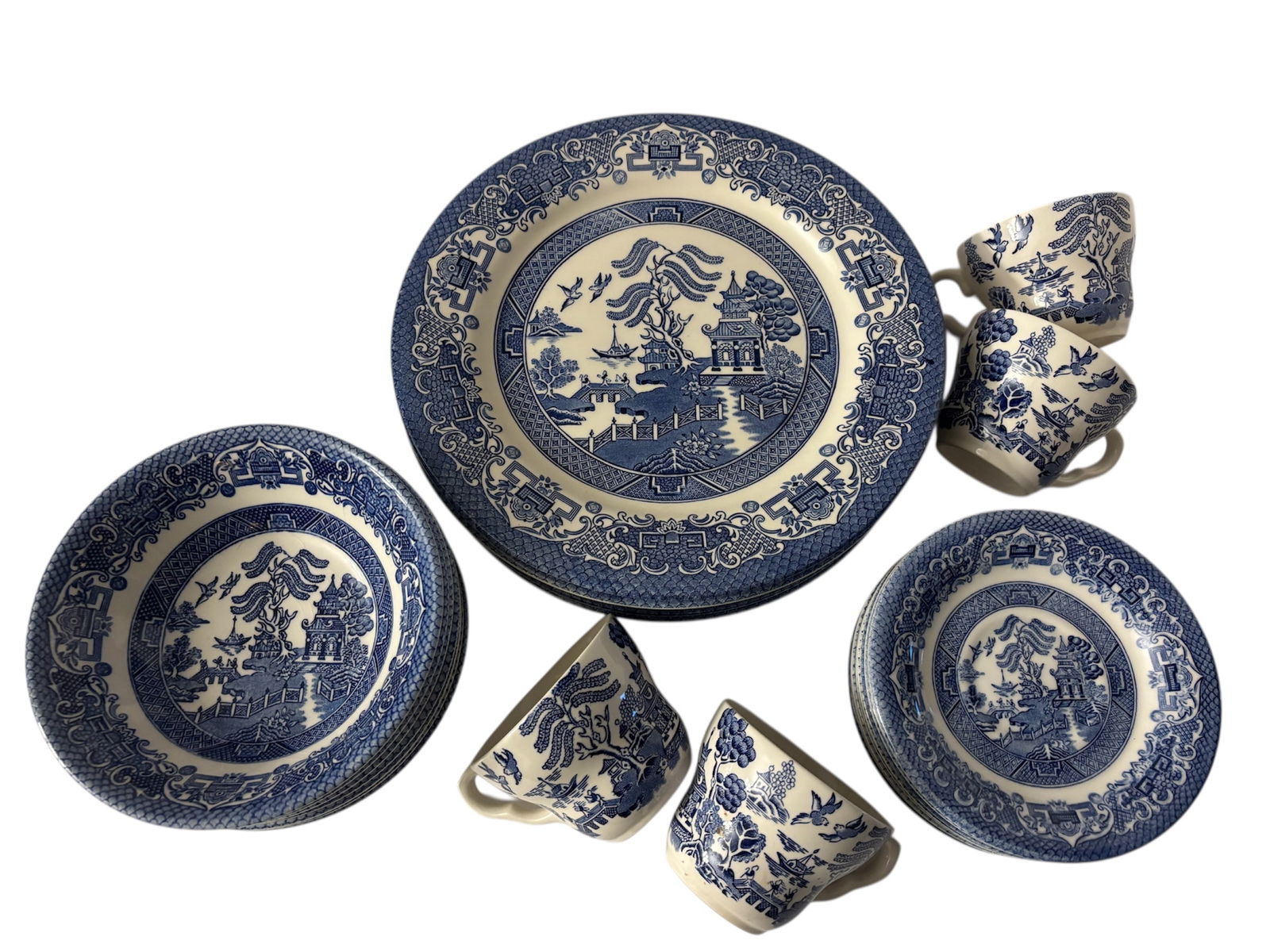 Classic Blue Willow English Ironstone Tableware: Featuring English ironstone blue and white transferware of the "Old Willow" pattern. 8 dinner plates 10.5", 7 bowls 6.5", 8 saucers 6" and 4 teacups from Manchester England manufacturer.