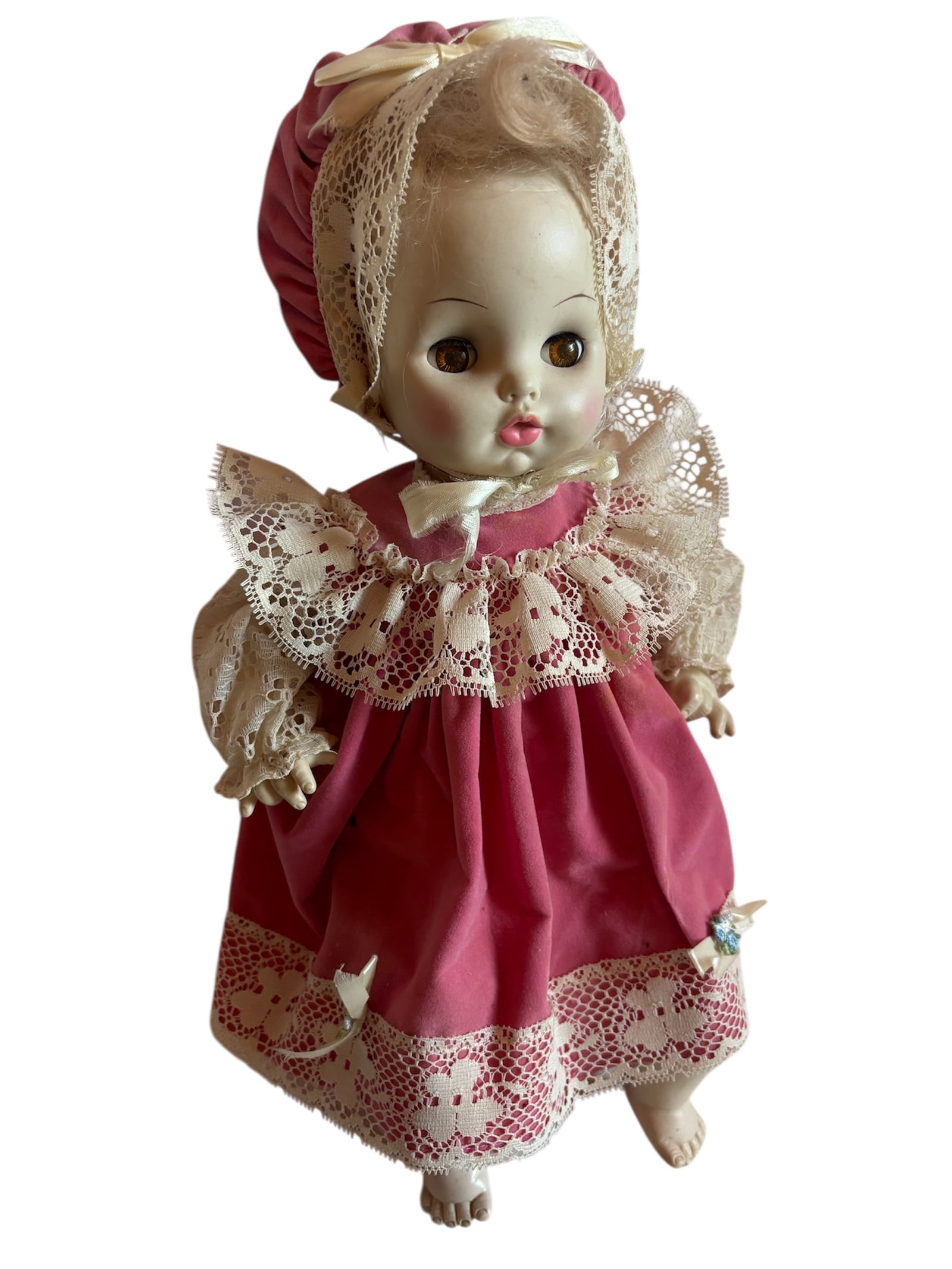 c 1969 Horsman Doll "Lynette": Soft body replica of an antique porcelain doll 16" , 1960-70s with sleepy eyes and vinyl limbs in a pink velvet dress with white lace trim and matching bonnet. Included in lot a small baby doll quilt
