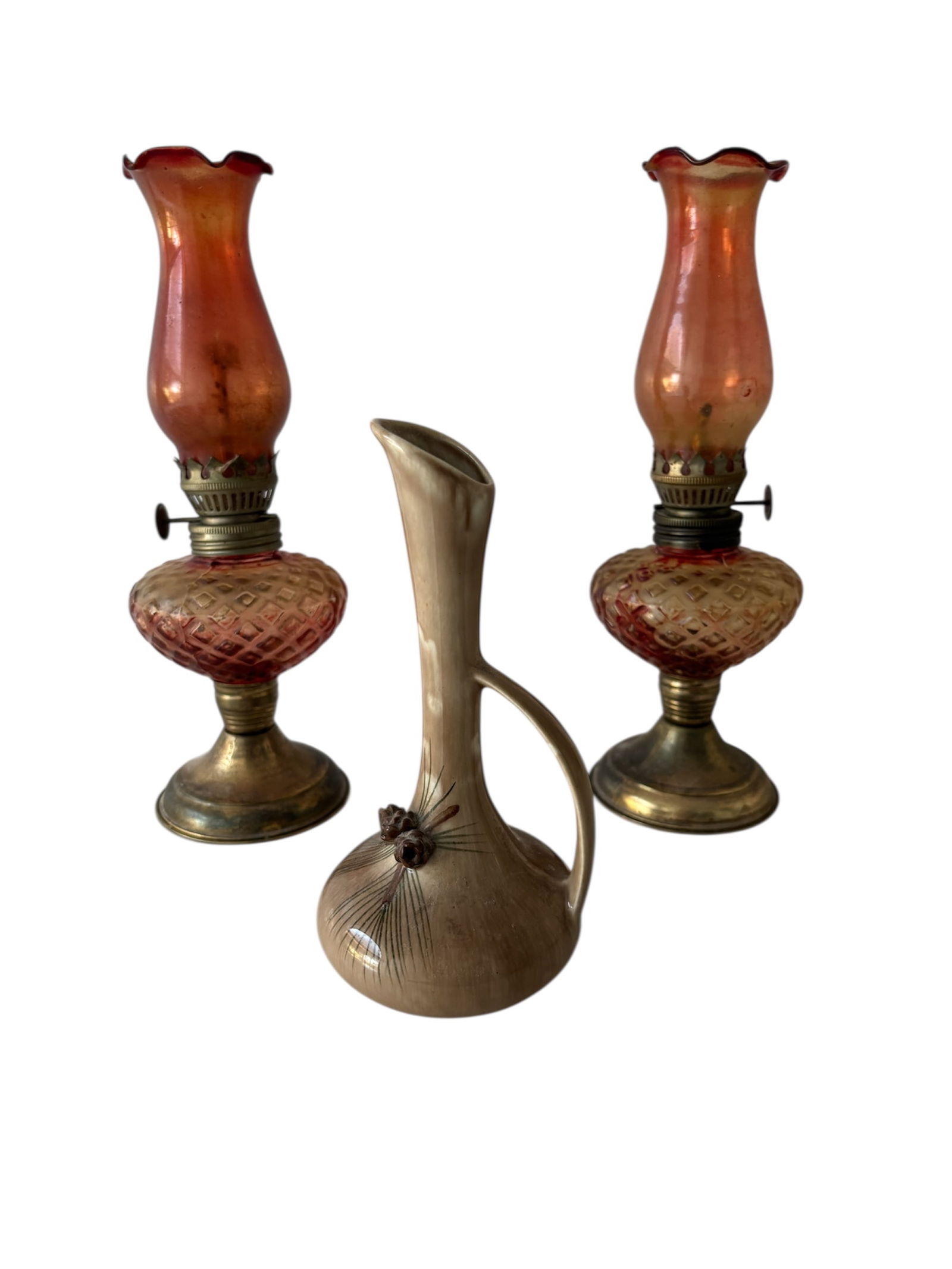 Pair of Antique 10" Kerosene Lamps & Studio Art Pinecone Bud Vase: Features a red flash over amber glass with a ruffled top and raised diamond pattern base. Brass/metal burner. 10". Also included c 1960 3 dimensional pine cones applied and hand painted pine needles w