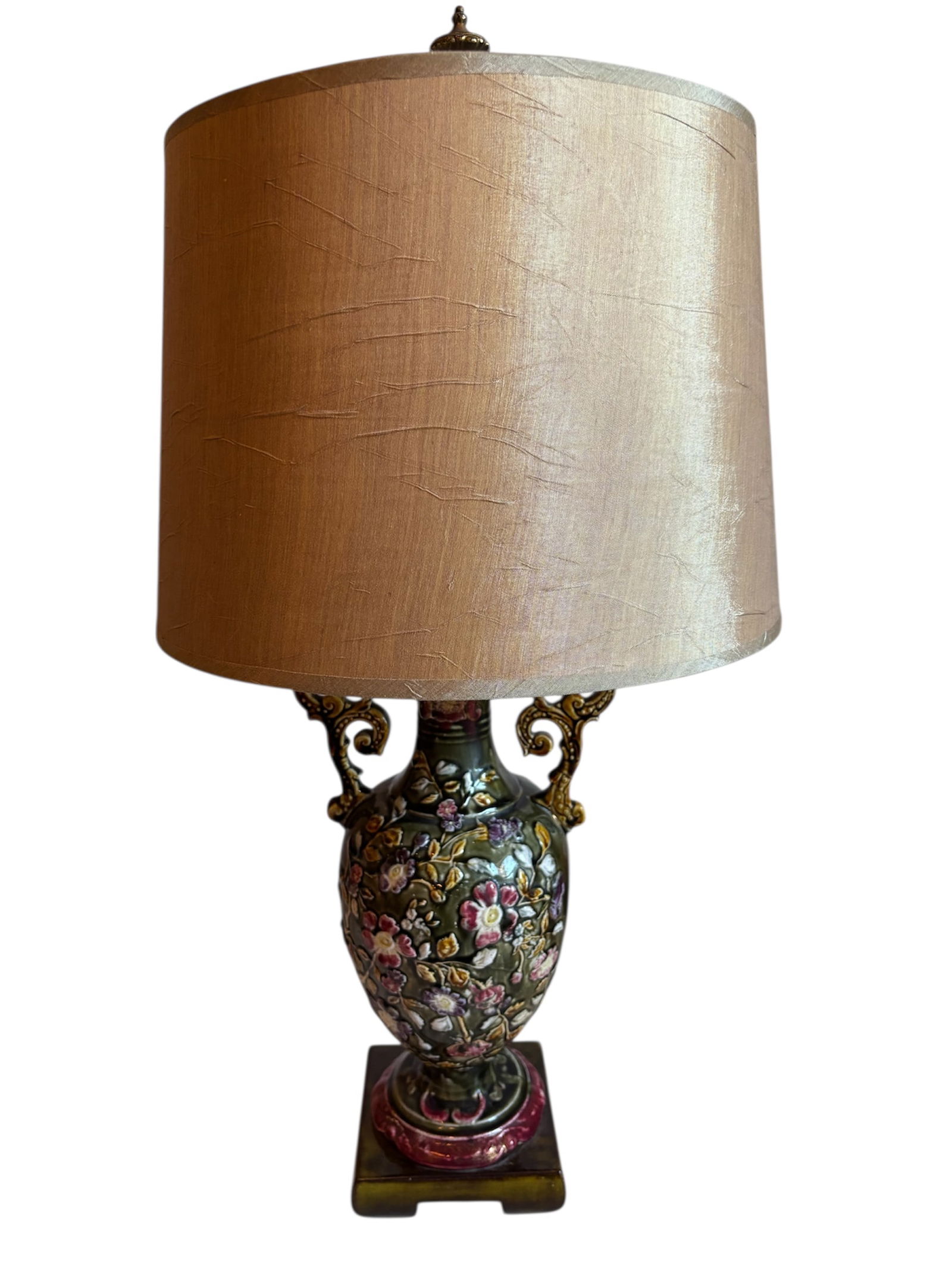 Ornate Art Nouveau Style Ceramic Lamp: Vibrant green, pink and rose tones with elaborate raised floral design throughout body with urn shaped base on pedestal with gold shade.