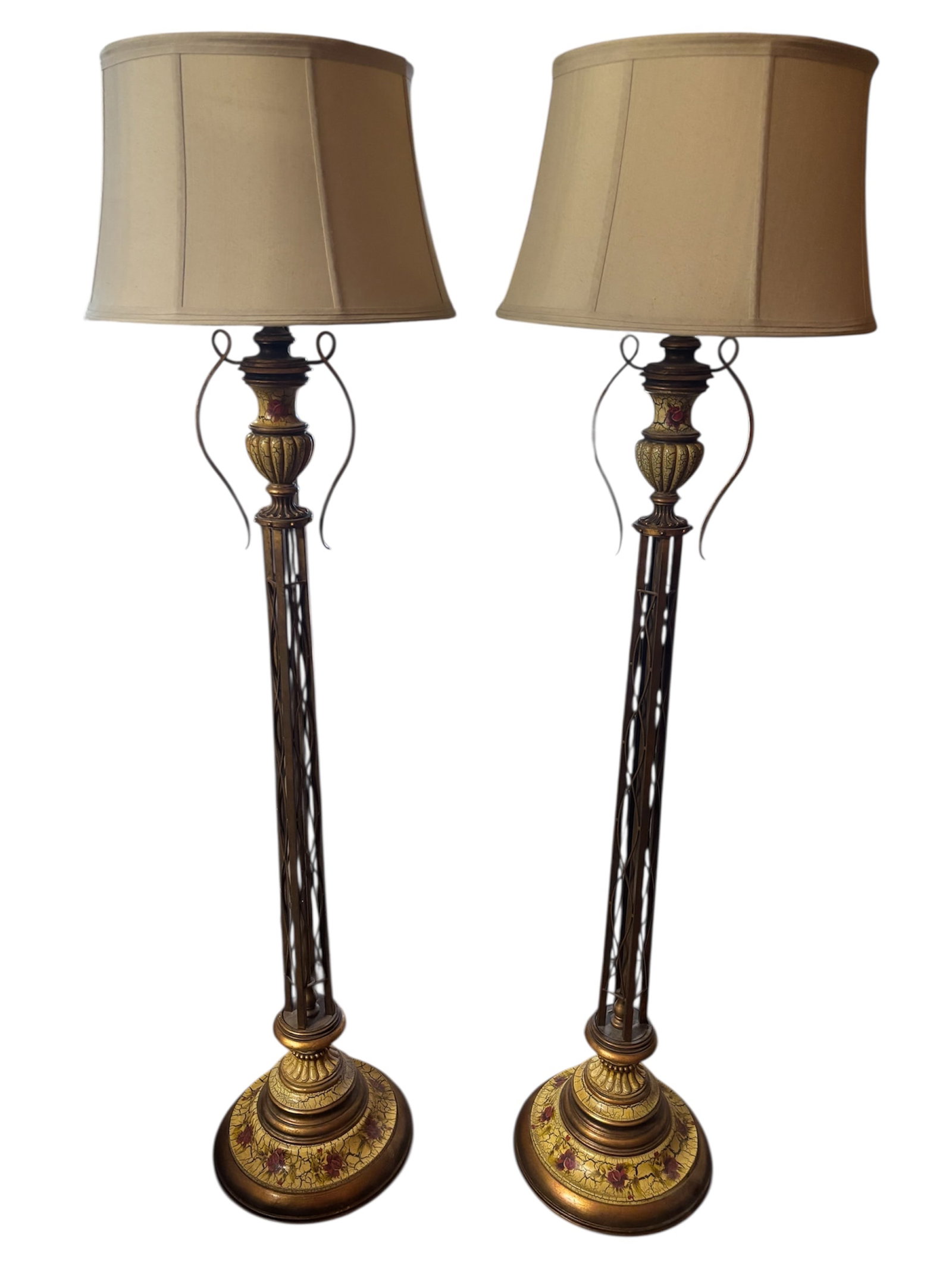 Pair of Ornate Open Ironwork Floor Lamps: Open ironwork floor lamps with pedestal base, floral motif accents and gilt finish. Center has urn like scrollwork, exaggerated crackle finish design and antiqued bronze finish on metal with decorativ