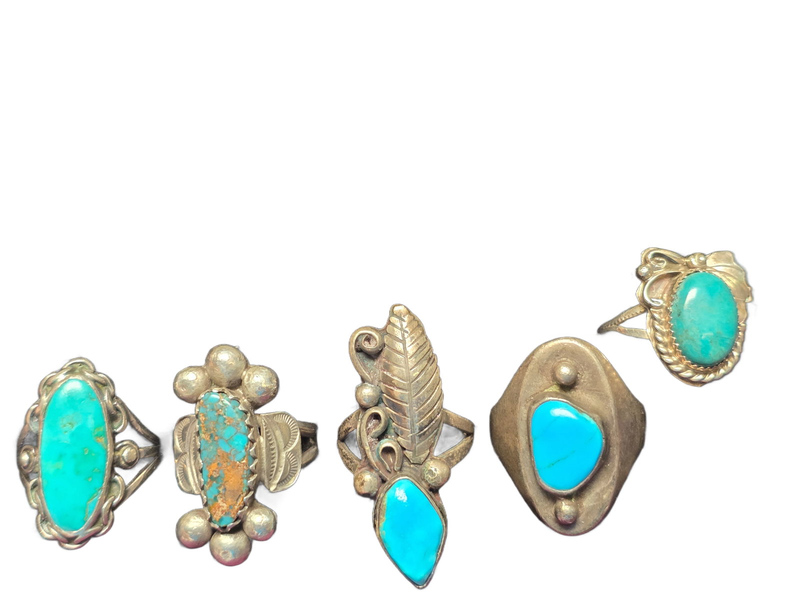 GROUP OF FIVE NATIVE AMERICAN STERLING SILVER TURQUOISE RINGS: A compelling group of five Native American sterling silver rings, each set with vibrant turquoise stones, showcasing a range of traditional and mid-century design influences. The lot features five nat