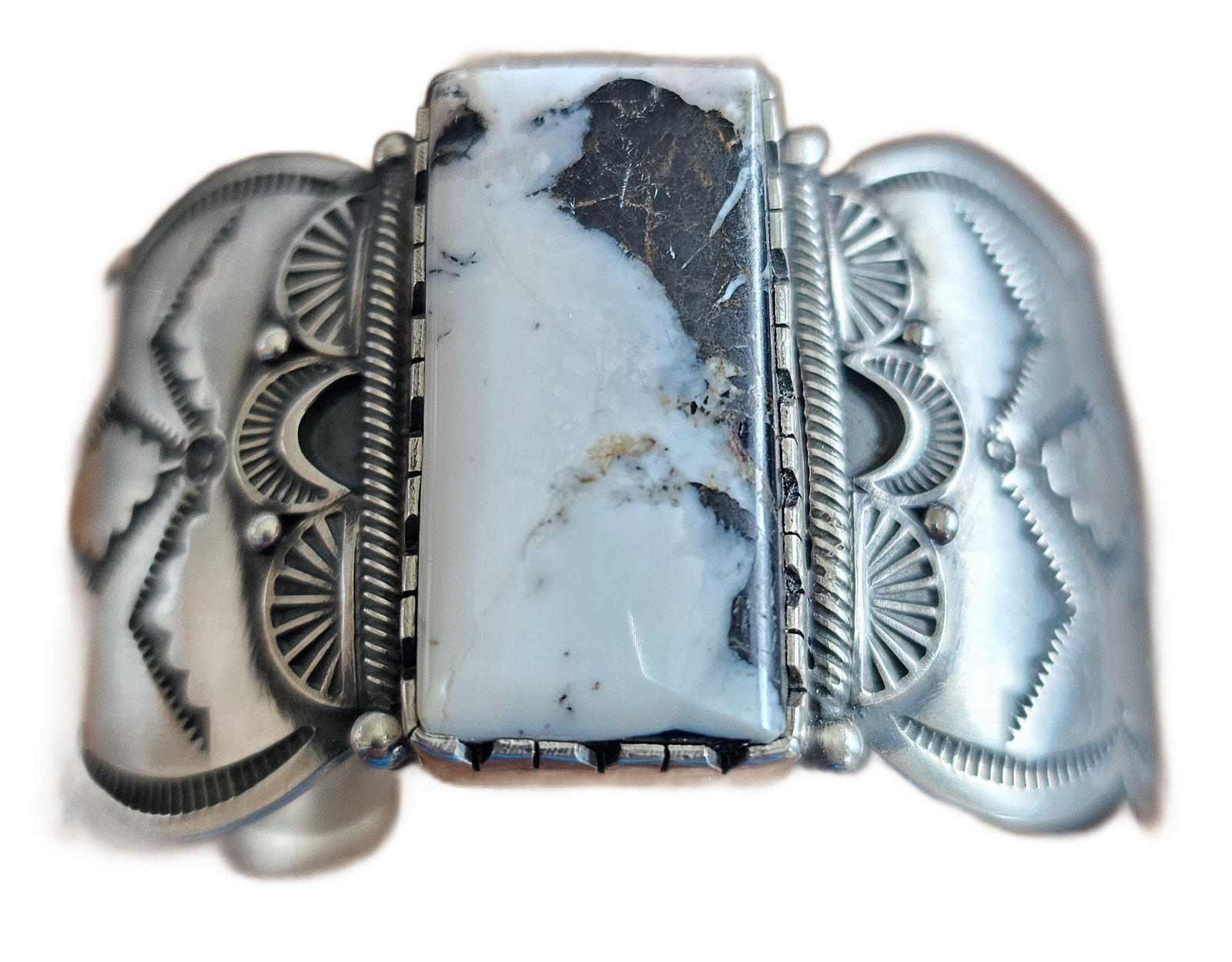 HEAVY STERLING SILVER CUFF BRACELET WITH BUFFALO TURQUOISE, ATTRIBUTED TO CAROLYN POLLOCK: A substantial and visually striking sterling silver cuff bracelet set with a bold rectangular buffalo (white) turquoise stone, exhibiting dramatic black matrix against a creamy white ground. The stone