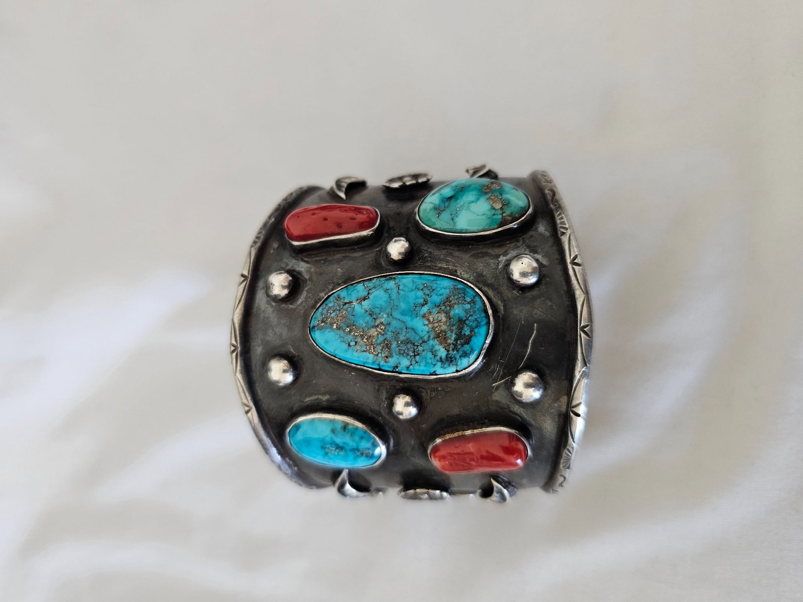 Wide Sterling Silver Turquoise Coral Cuff Bracelet 92.34g: Substantial wide sterling silver cuff bracelet featuring a bold combination of turquoise and coral set across a heavily oxidized silver face.The bracelet is centered by a large turquoise cabochon with