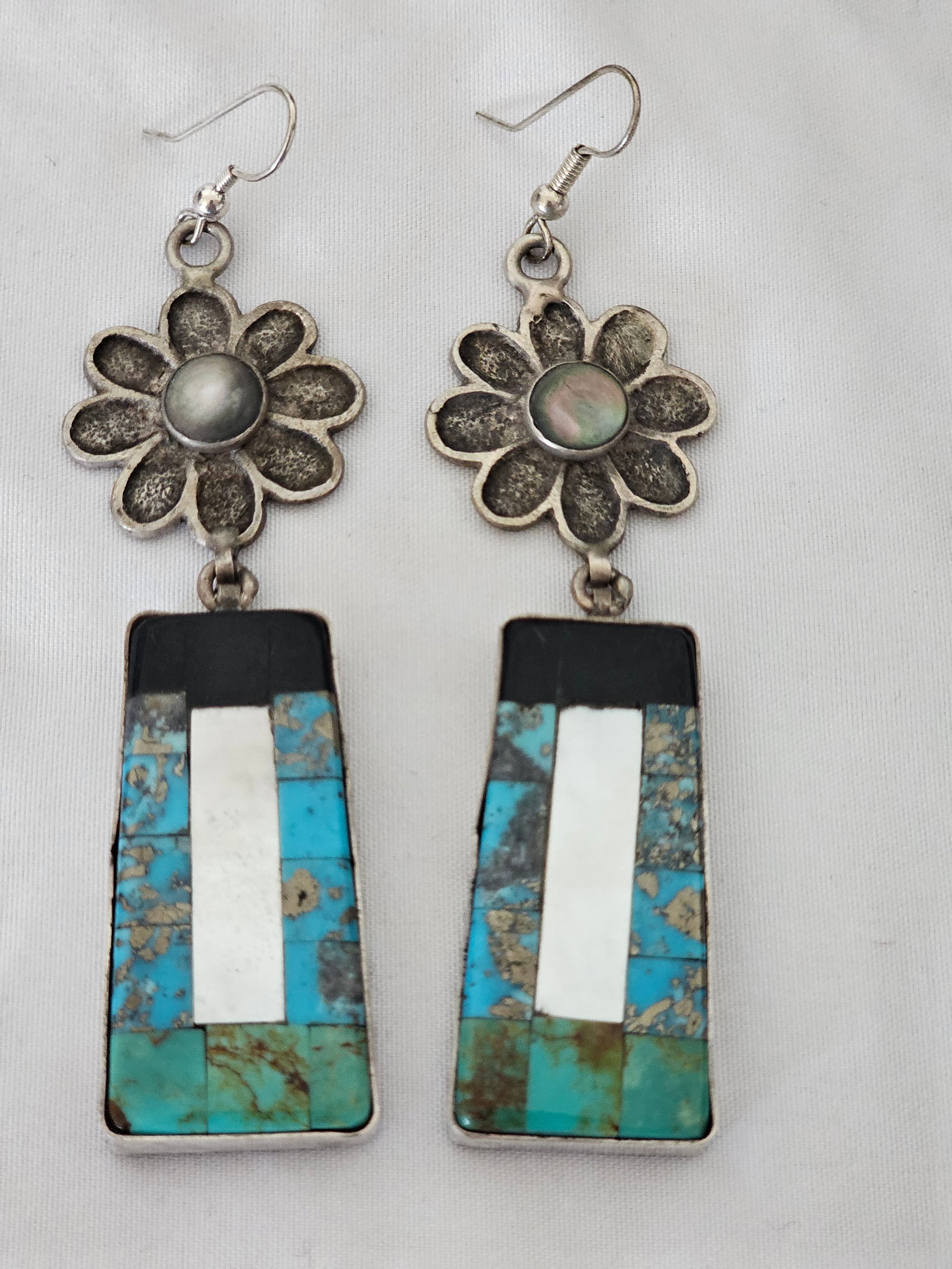 Mathew Lovato Kewa Tufa Cast Sterling Silver Inlay Dangle Earrings 28.51g: New sterling silver dangle earrings by Mathew Lovato of Kewa Pueblo. Each earring features a tufa-cast flower-form top with a quartz center and a geometric drop inlaid with mother-of-pearl, turquoise,