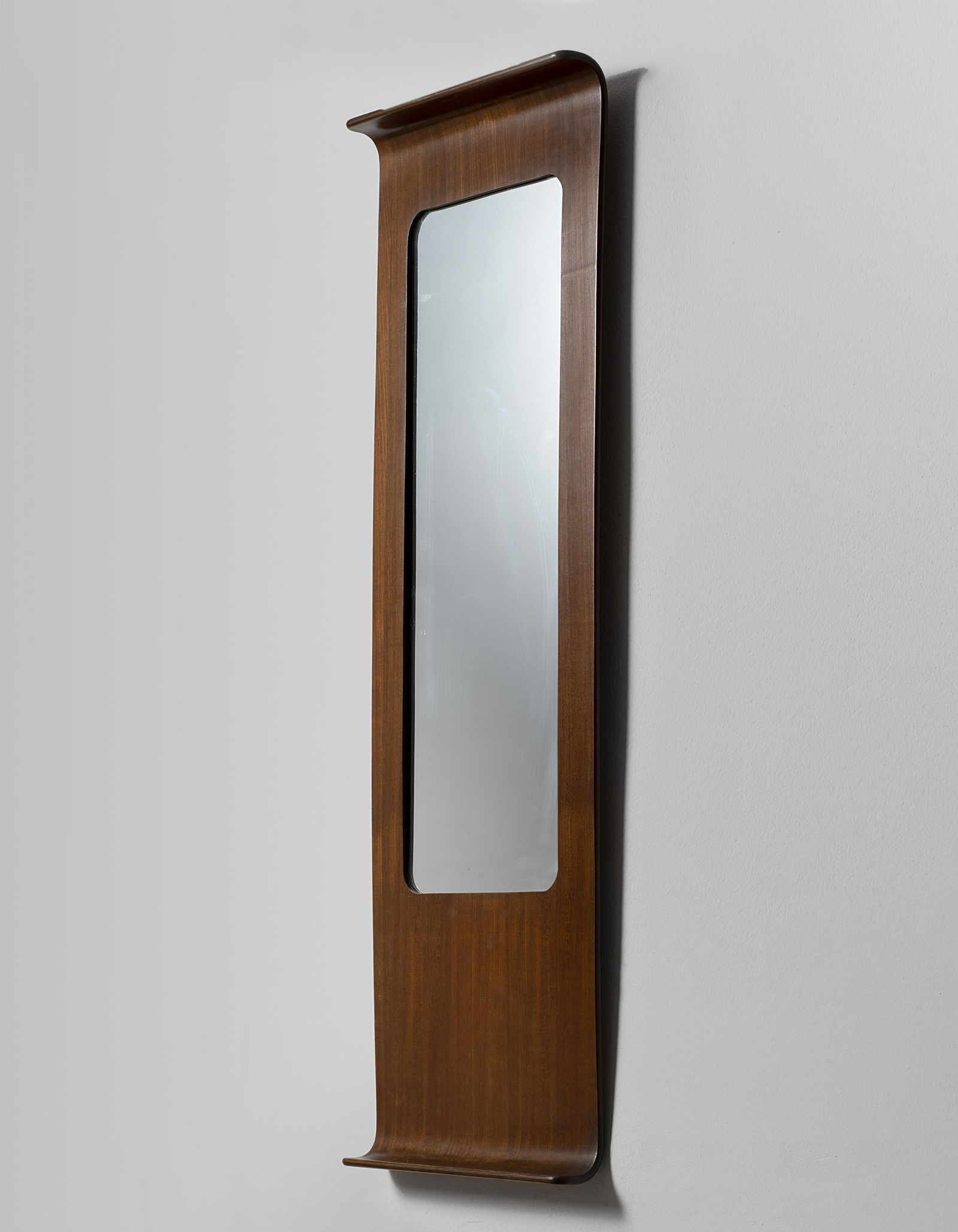 In the style of Franco Campo and Carlo Graffi Mirror,: In the style of Franco Campo and Carlo Graffi Mirror, 1960s Mirrored glass, walnut-veneered plywood. 120 x 40 x 10.5 cm Manufactured by Arredamenti Mobel, Turin, Italy. Reverse with manufacturer's pap