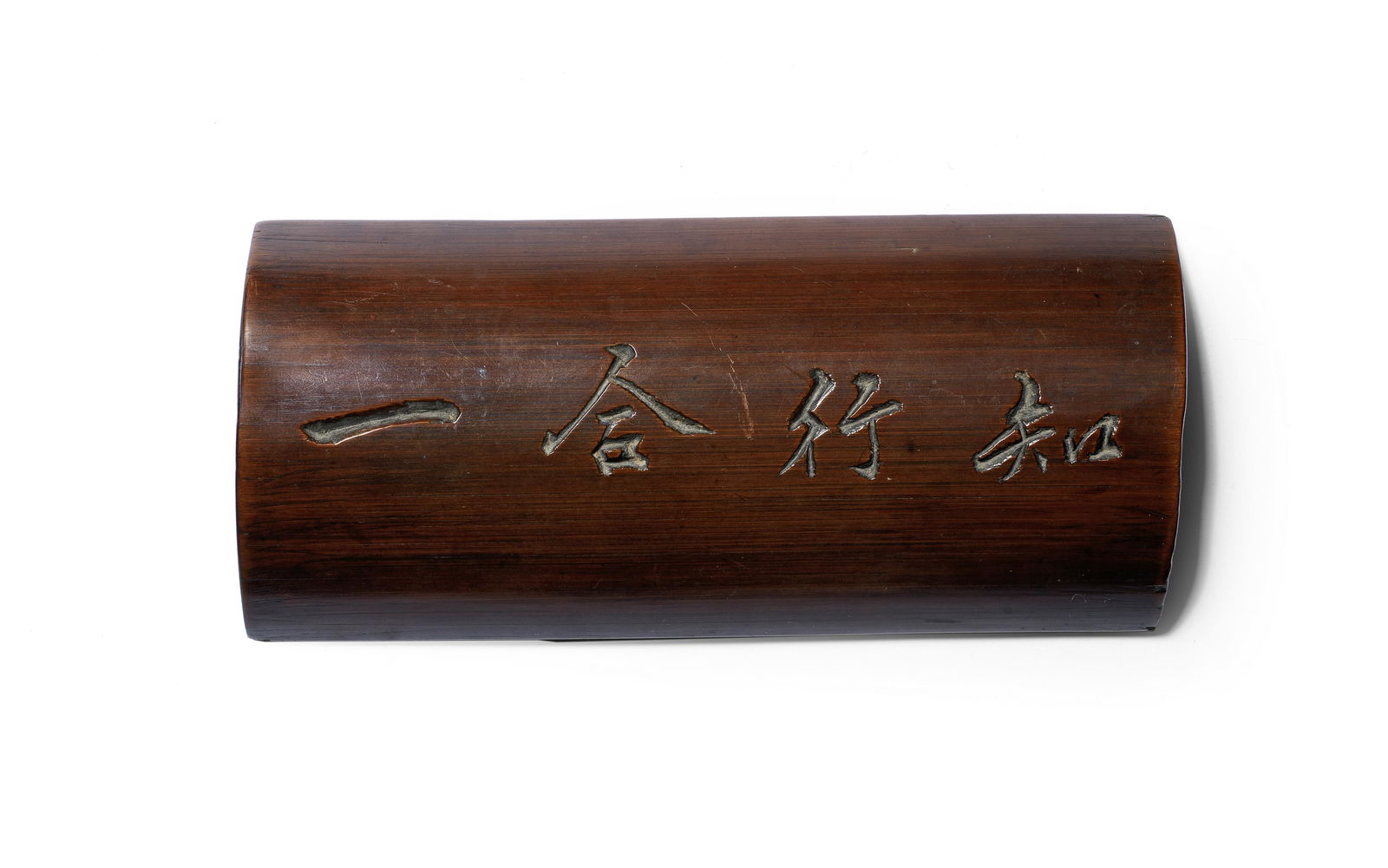 A BAMBOO INSCRIBED WRISTREST 18th/19th century: A BAMBOO INSCRIBED WRISTREST 18th/19th century The rounded section of bamboo carved with the maxim of the Ming dynasty philosopher Wang Yangming, Zhi xing he yi, in running script calligraphy, the bam
