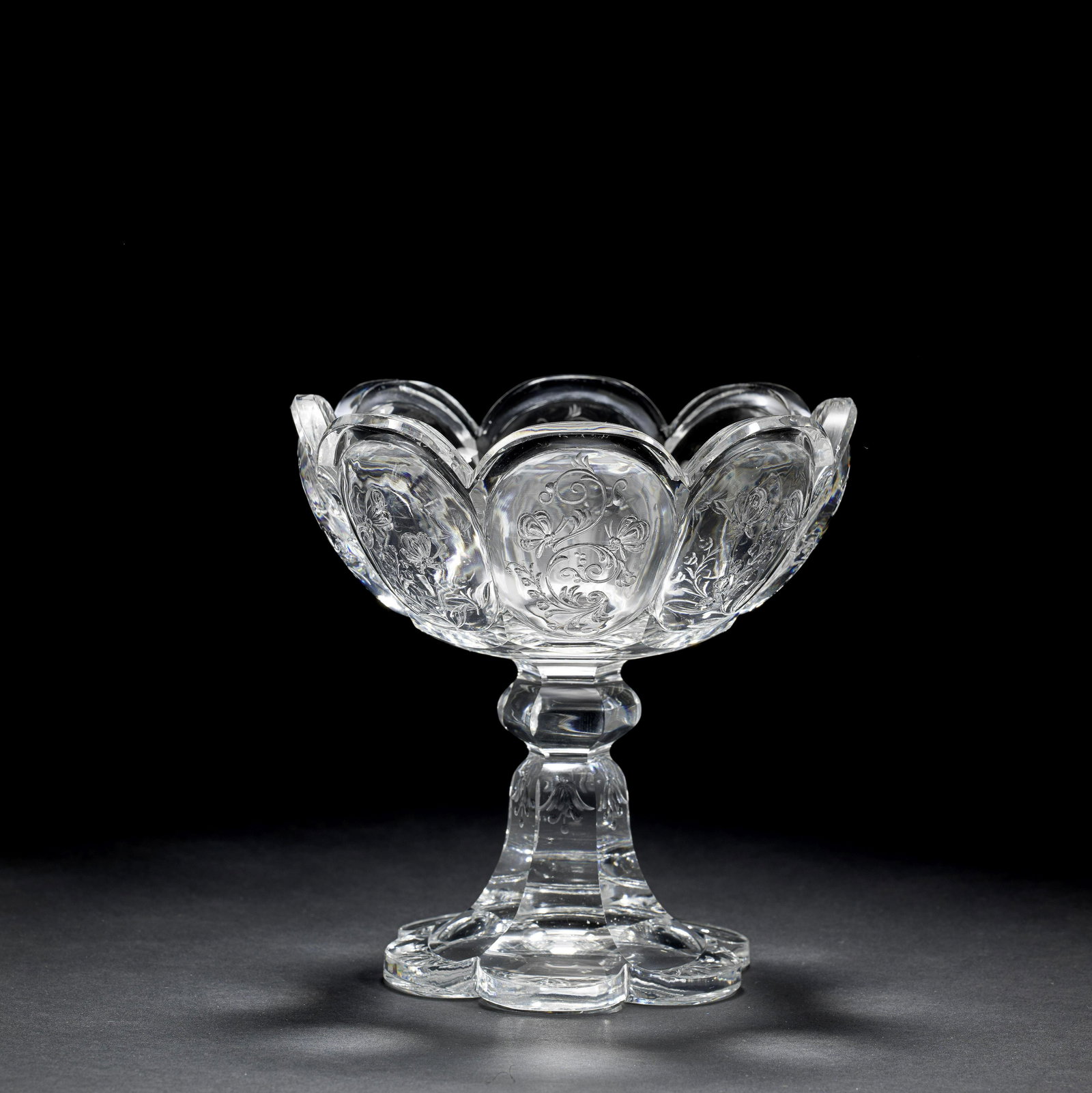 A Stevens and Williams 'rock crystal' style engraved: A Stevens and Williams 'rock crystal' style engraved comport, circa 1895-1900 Perhaps by John Orchard, the scalloped bowl finely carved with eight arcaded panels, four each with a pair of butterflies